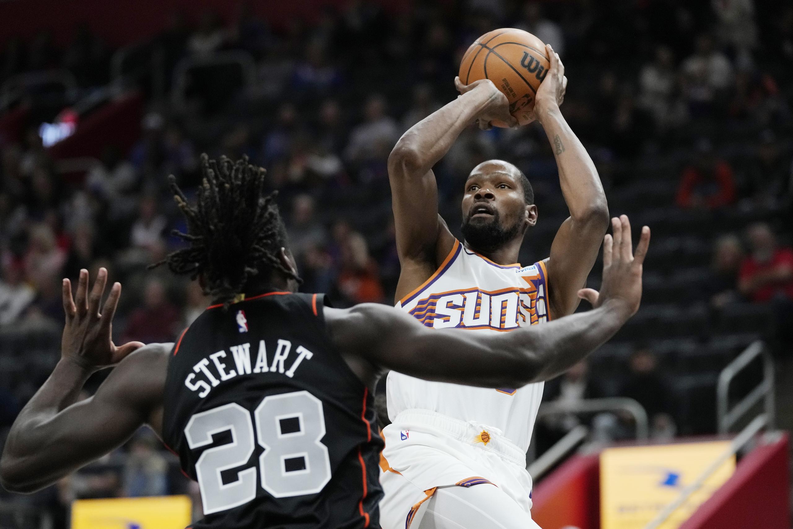 Kevin Durant, de los Suns de Phoenix, dispara ante la marca defensiva de Isaiah Stewart (28), de los Pistons de Detroit, durante la primera mitad del juego de baloncesto de la NBA, el domingo 5 de noviembre de 2023, en Detroit. (AP Foto/Carlos Osorio)