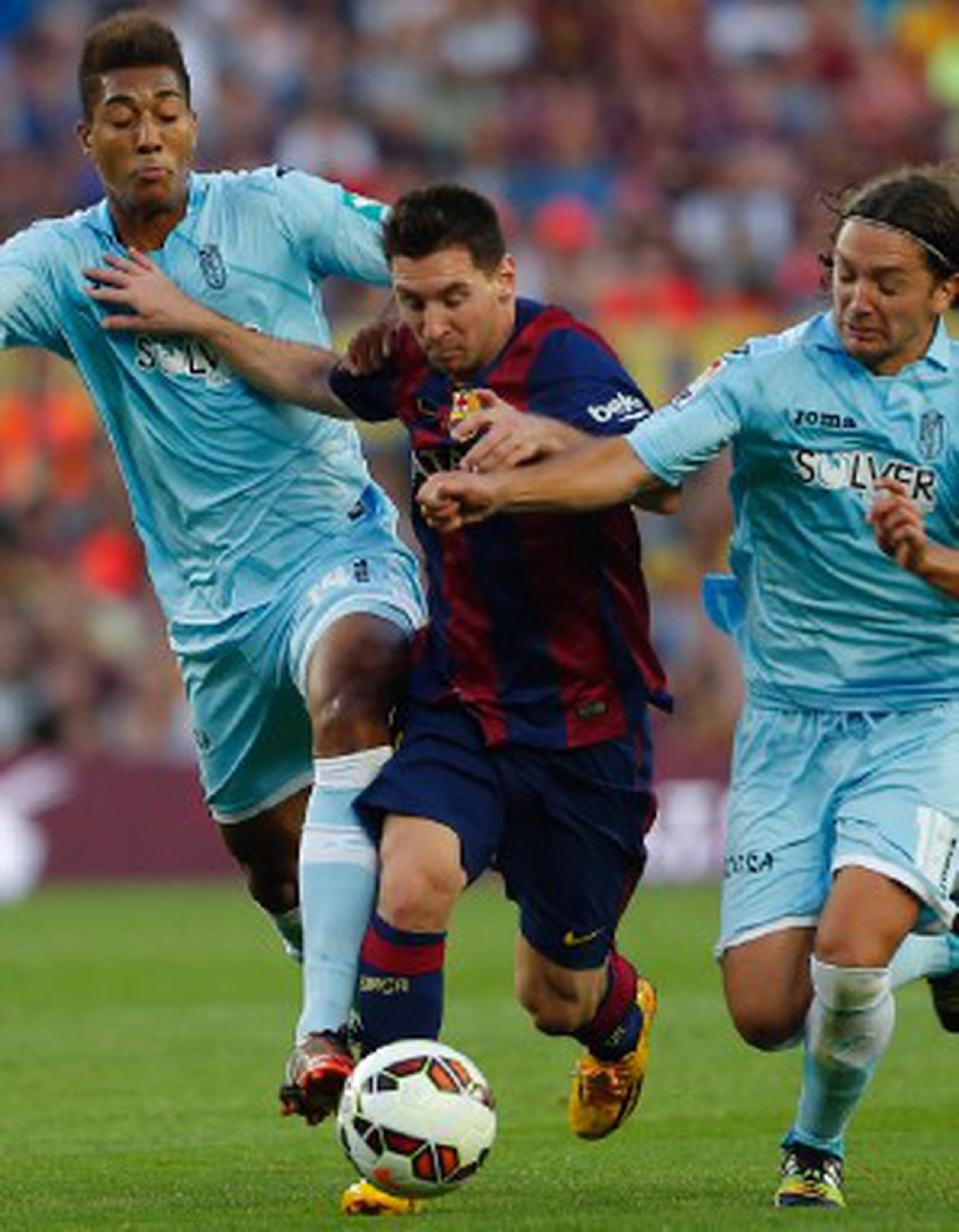 El argentino Lionel Messi, al centro, lucha por el control del balón contra Eddy Silvestre, a la izquierda, y Manuel Iturra, del Granda durante su encuentro del sábado. (AP / Emilio Morenatti)