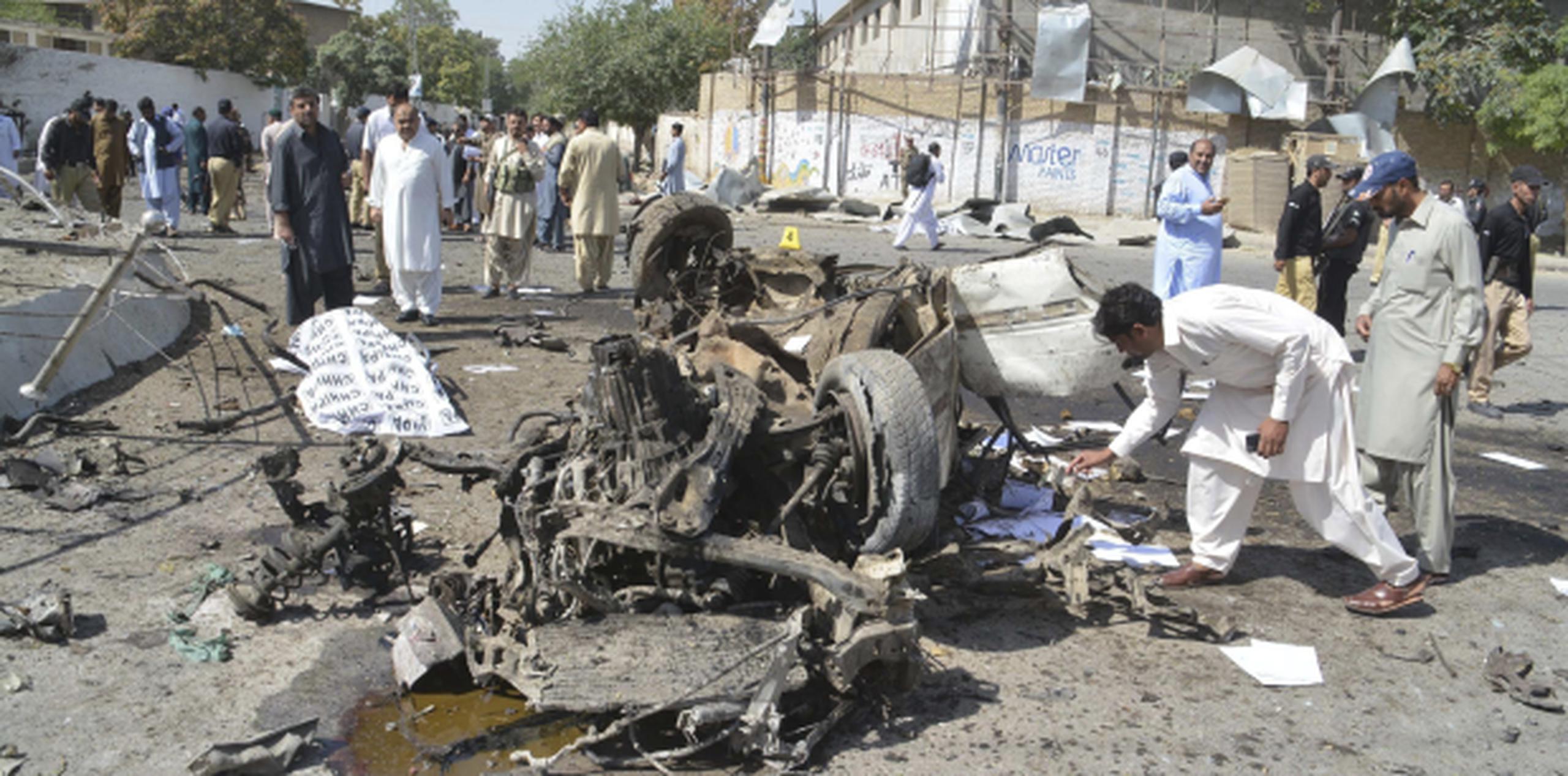 Miembros de fuerzas de seguridad observan los restos de un auto usado como coche bomba el viernes en Quetta, en un ataque en el murieron al menos 14 personas. (EFE/Jamal Taraqai)
