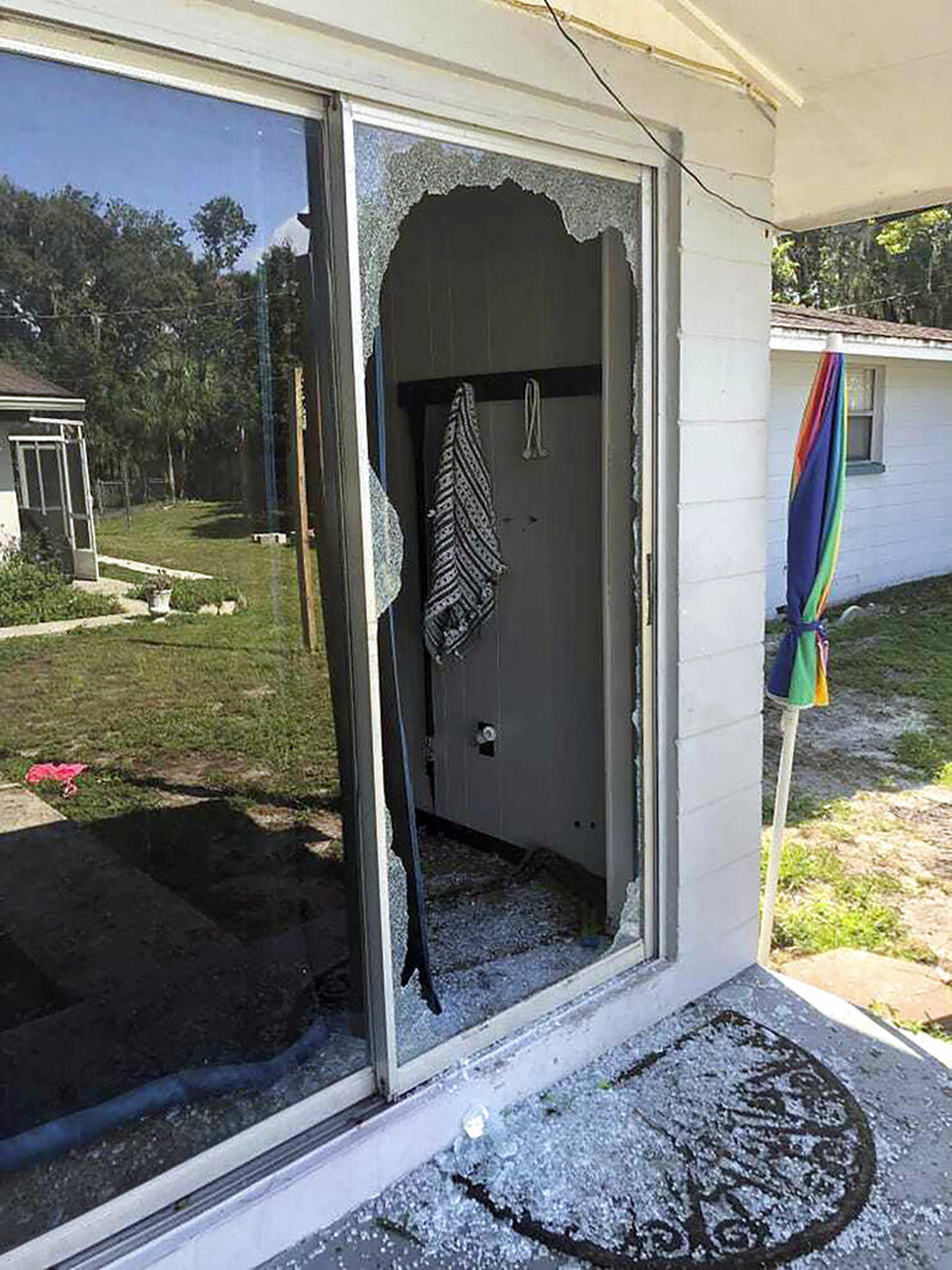 Esta imagen proporcionada por la Oficina del Sheriff del condado de Polk muestra la parte trasera de la residencia donde un teniente del alguacil de Polk entró a la casa e intercambió disparos con un sospechoso de disparar en un vecindario en Lakeland, Florida.