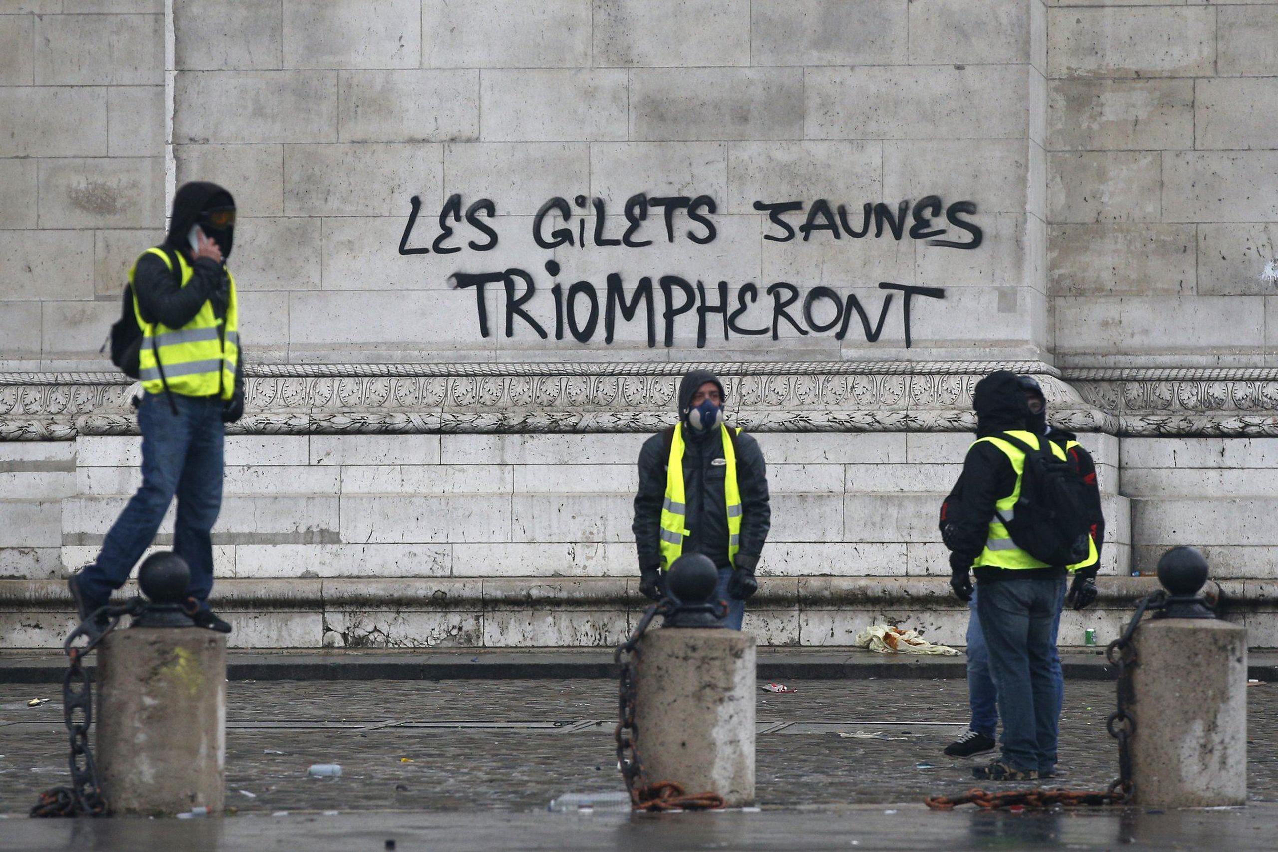 Grafiti que lee "las chaquetas amarillas triunfarán" en la base del Arco de Triunfo. (AP / Thibault Camus)