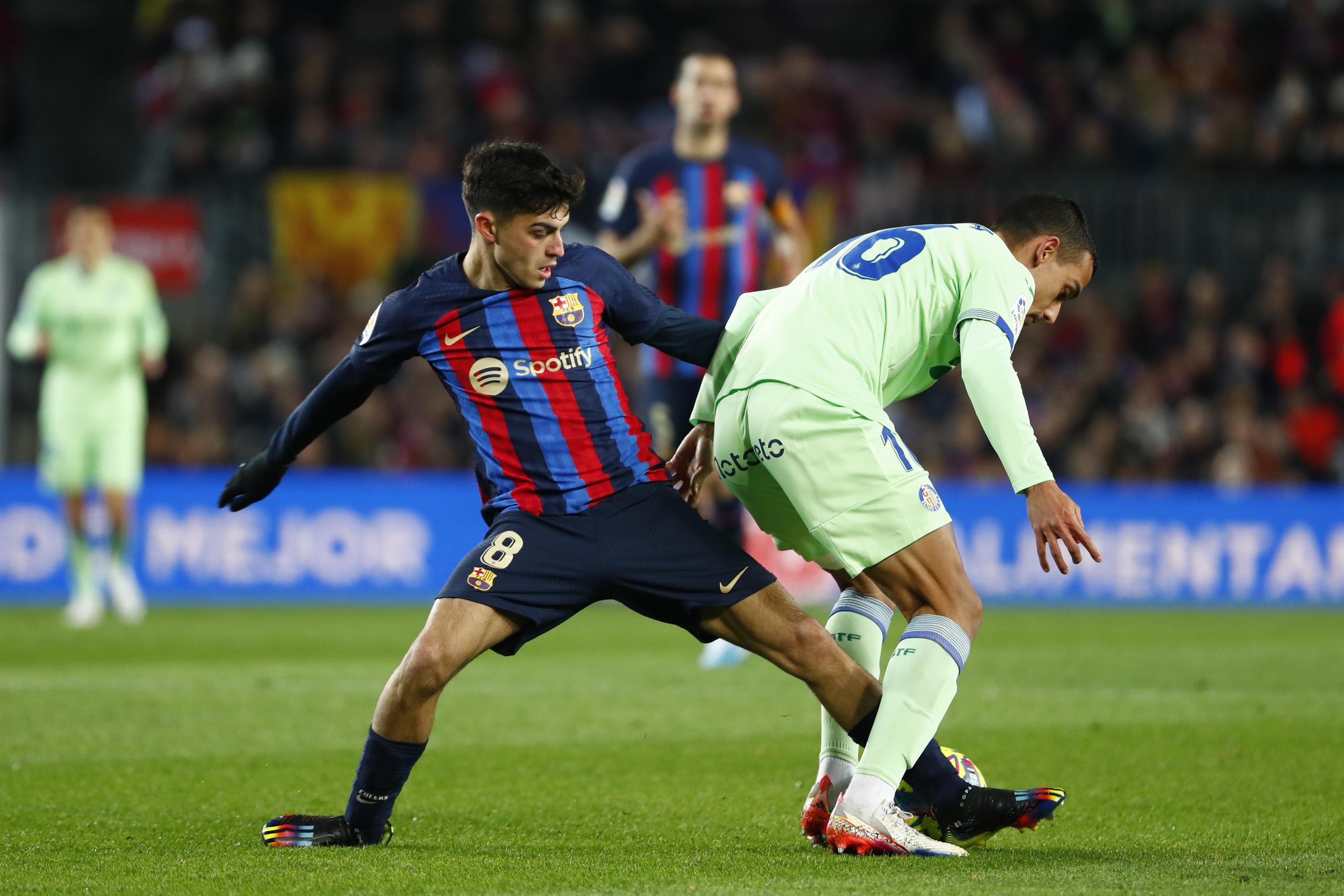 Pedri (izquierda) del Barcelona pugna el balón con Ángel Algobia del Getafe en el partido de la Liga española, el domingo 222 de enero de 2023. (AP Foto/Joan Monfort)