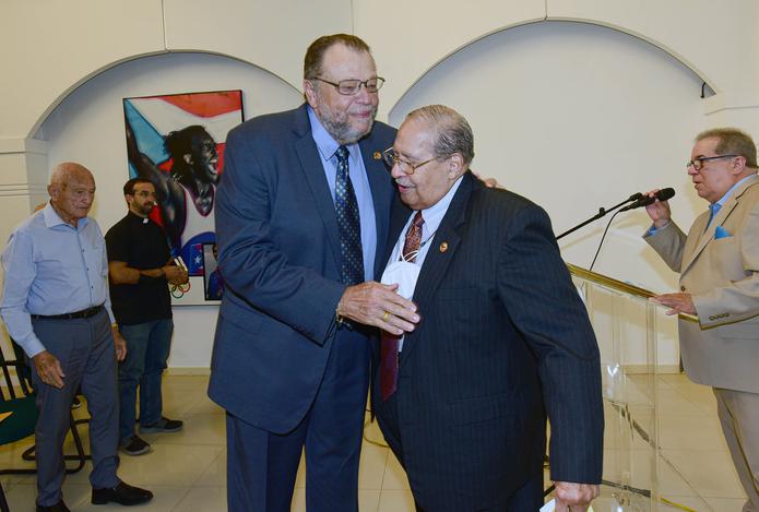 José Julián Álvarez -a la izquierda- es felicitado por Jimmy Thordsen  (presidente del Pabellón de la Fama del Deporte Puertorriqueño) durante la actividad celebrada en recientemente.