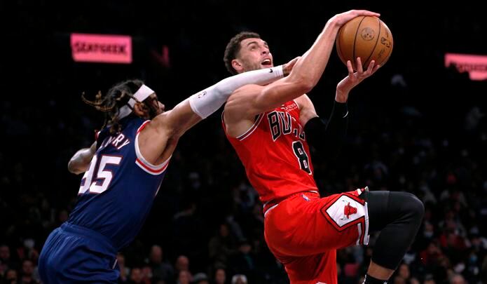 El base de los Bulls de Chicago, Zach LaVine, recibe una falta de DeAndre Bembry, de los Nets de Brooklyn, mientras avanza hacia el canasta durante el encuentro del sábado.