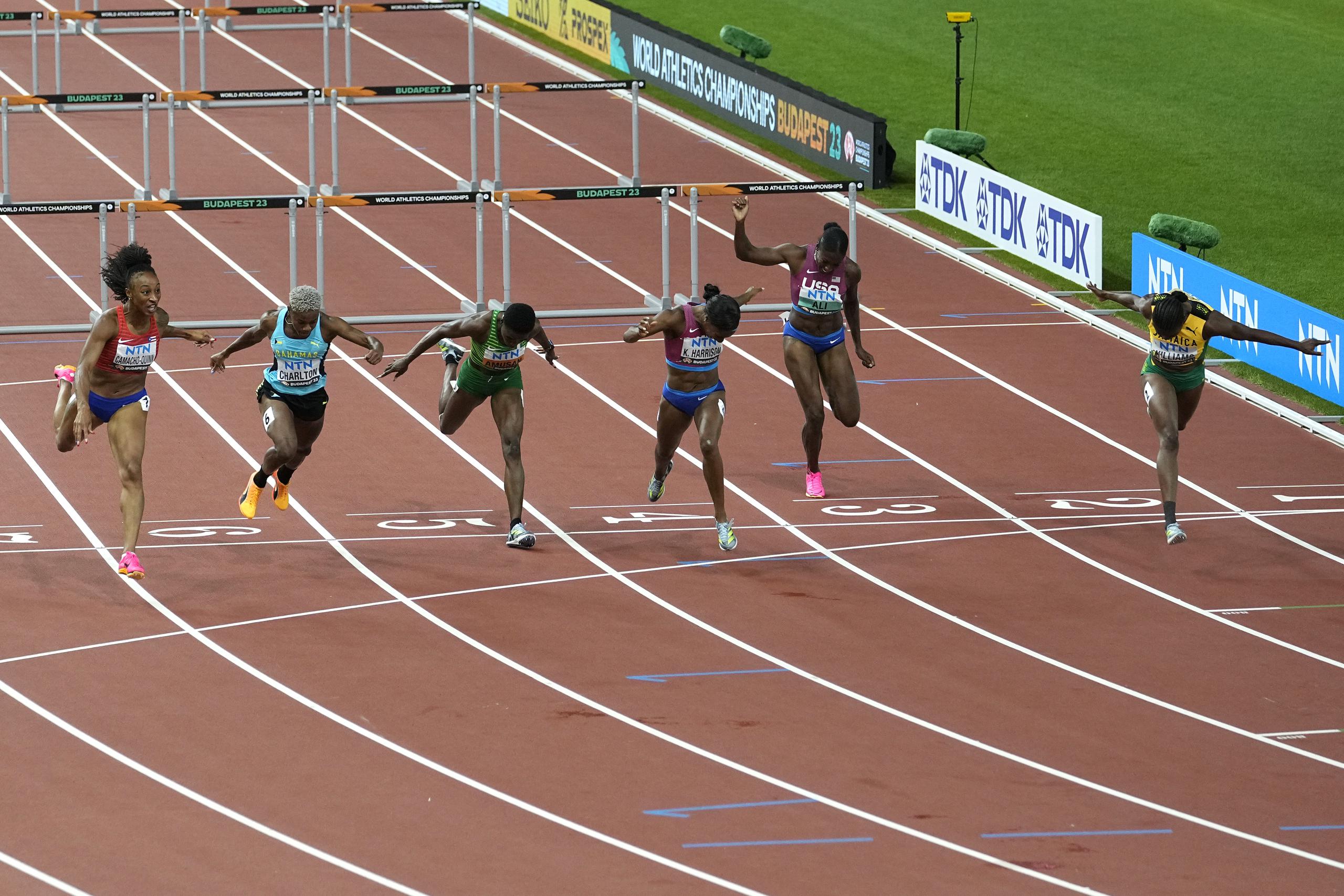 Danielle Williams, de Jamaica, por el carril número 1, completa su corrida mientras el resto de las corredoras, incluida Jasmine Camacho Quinn, a la izquierda, hacían su esfuerzo final por ganar la prueba. Williams se llevó el oro con 12.43 segundos y Camacho Quinn la plata con 12.44.