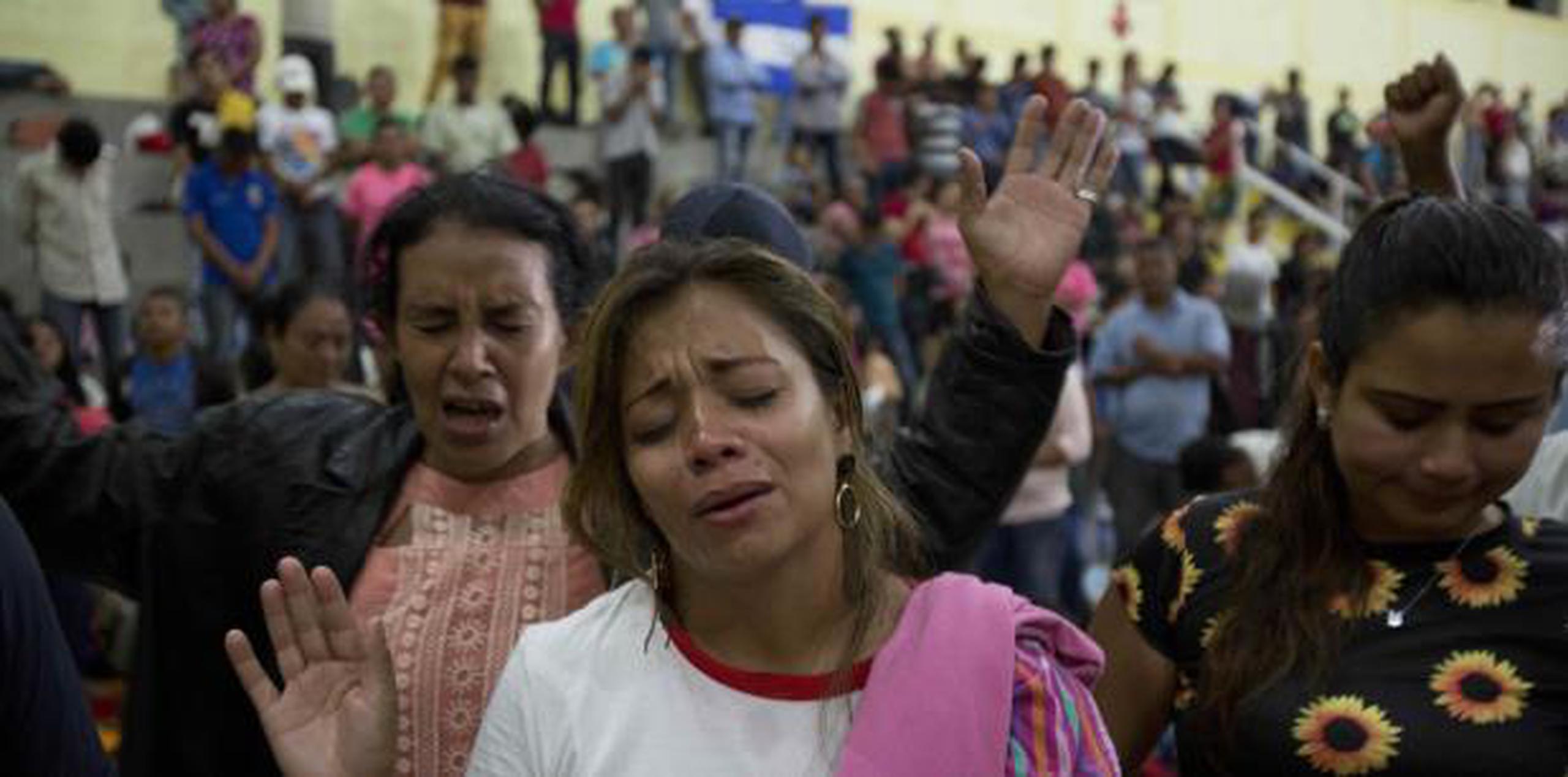 Algunas inmigrantes oran en Guatemala en medio de la gran caravana que partió desde Honduras en ruta a estados Unidos. (AP)