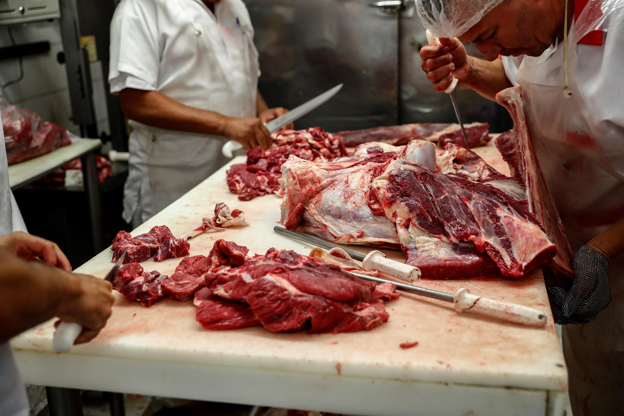 Carniceros preparan cortes de carne ayer viernes, en un mercado del centro de Sao Paulo (Brasil). Los brasileños están pagando la carne roja a precio de oro debido al fuerte aumento de las ventas a China y a la presión de un dólar en máximos históricos que ha estimulado las exportaciones.