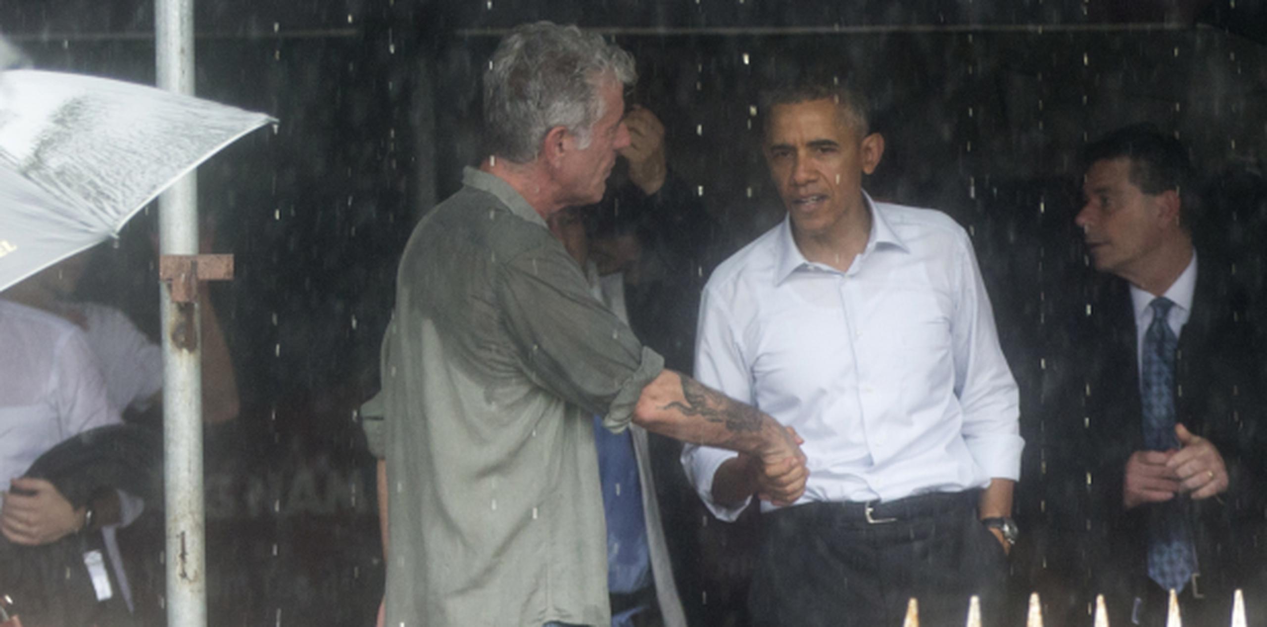 Bajo un torrencial aguacero, Obama se despide del popular chef y presentador Anthony Bourdain tras comer por $6 en un restaurante de Vietnam. (AP)
