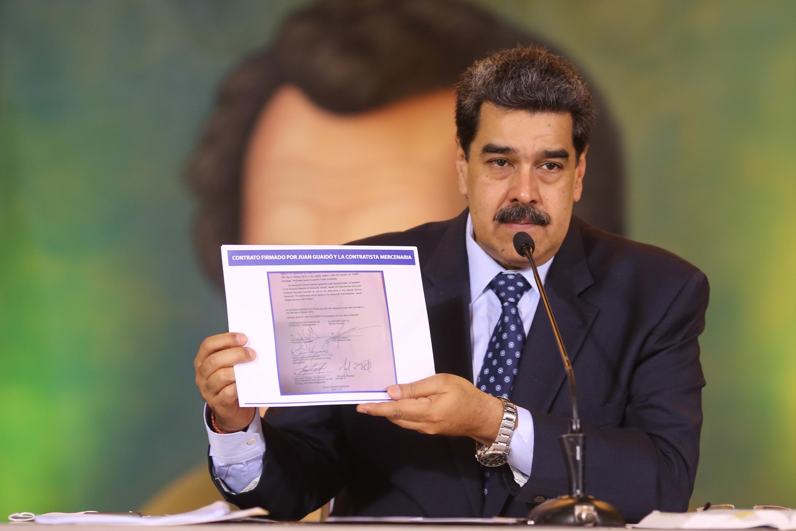 Nicolás Maduro acusa Juan Guaidó de ser el autor intelectual de un operativo militar para derrocarlo, mientras sostiene una copia de un acuerdo por escrito que supuestamente tiene la firma del líder opositor, como evidencia