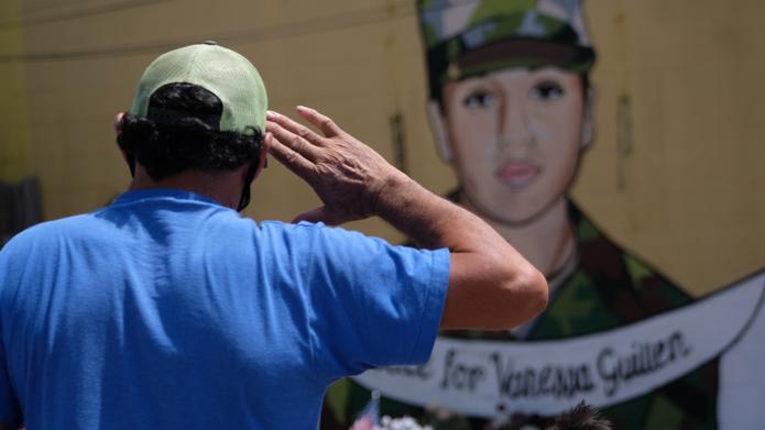 Un hombre hispano no identificado realiza un saludo militar frente al mural con la imagen de Vanessa Guillén, ubicado en un vecindario del sur de Houston, Texas.