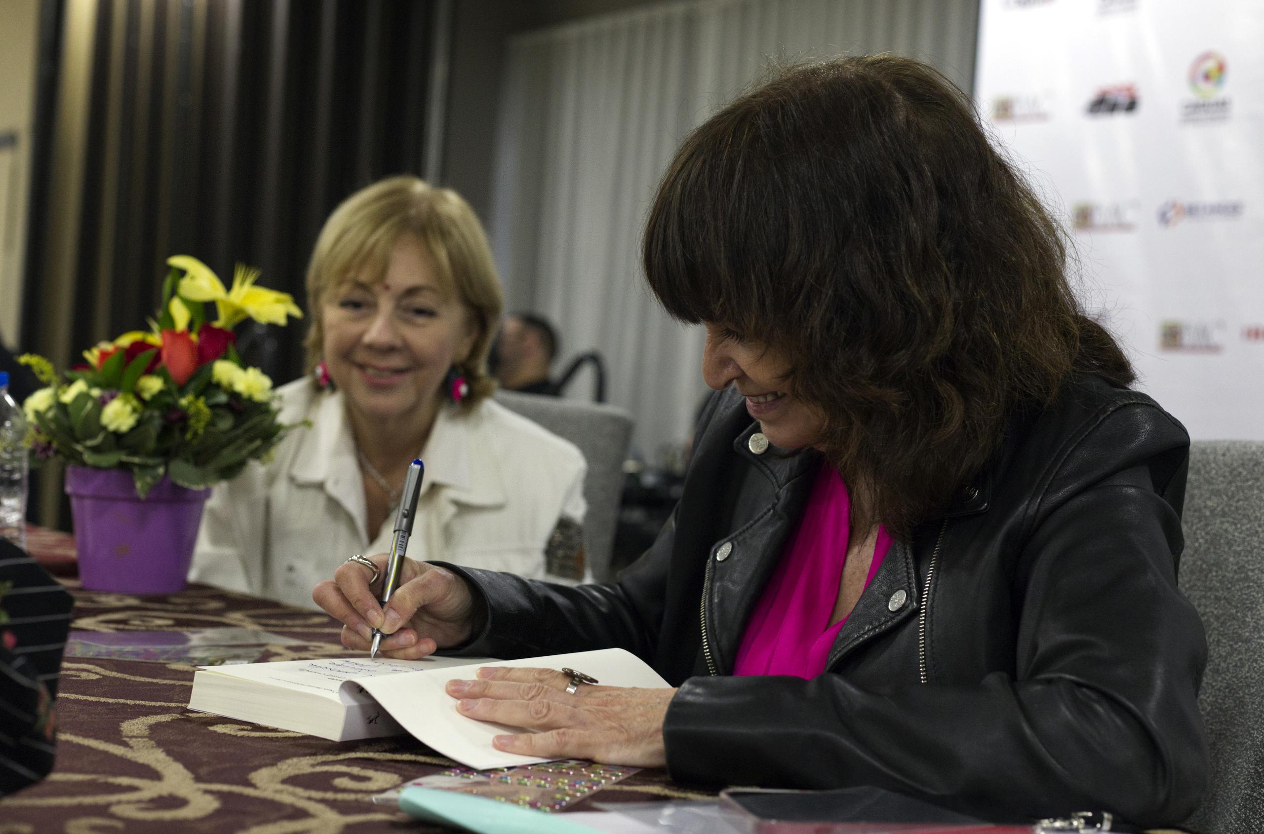 La escritora española Rosa Montero (derecha) y la puertorriqueña Mayra Montero (izquierda) autografían libros durante la inauguración del Primer Congreso Internacional de Escritores.