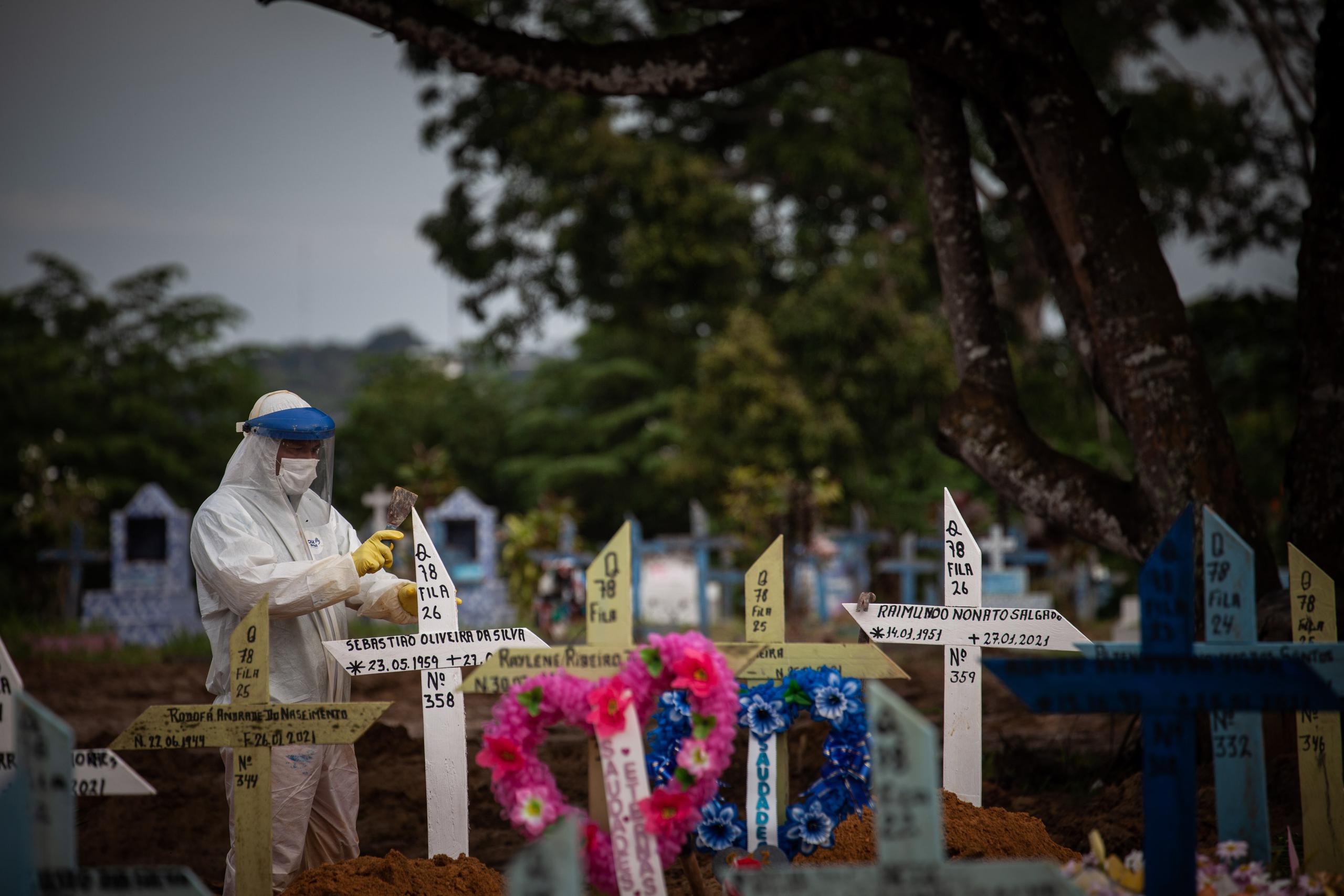 Un trabajador coloca cruces sobre la tumbas de personas fallecidas por covid-19, en el cementerio público Nossa Senhora Aparecida en Manaos, Amazonas, Brasil.