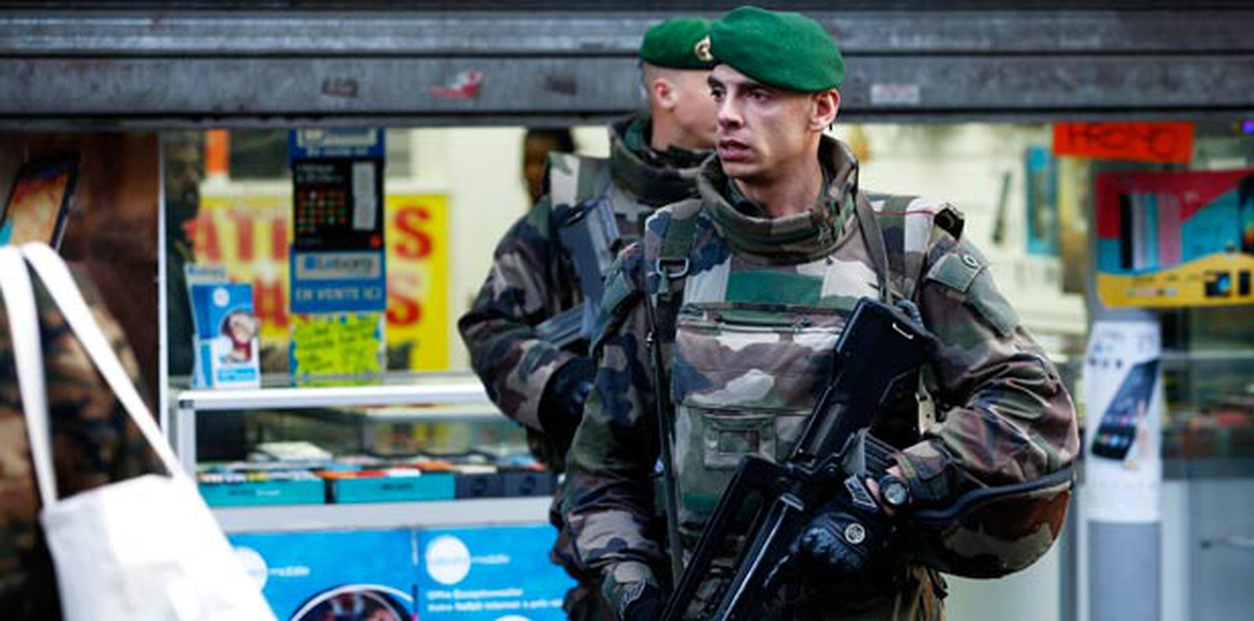 Dos militares patrullan cerca del lugar donde la Policía francesa mató al hombre armado que trató de atacar hoy una comisaría del barrio de la Goutte d'Or, al norte de París. (EFE/Yoan Valat)

