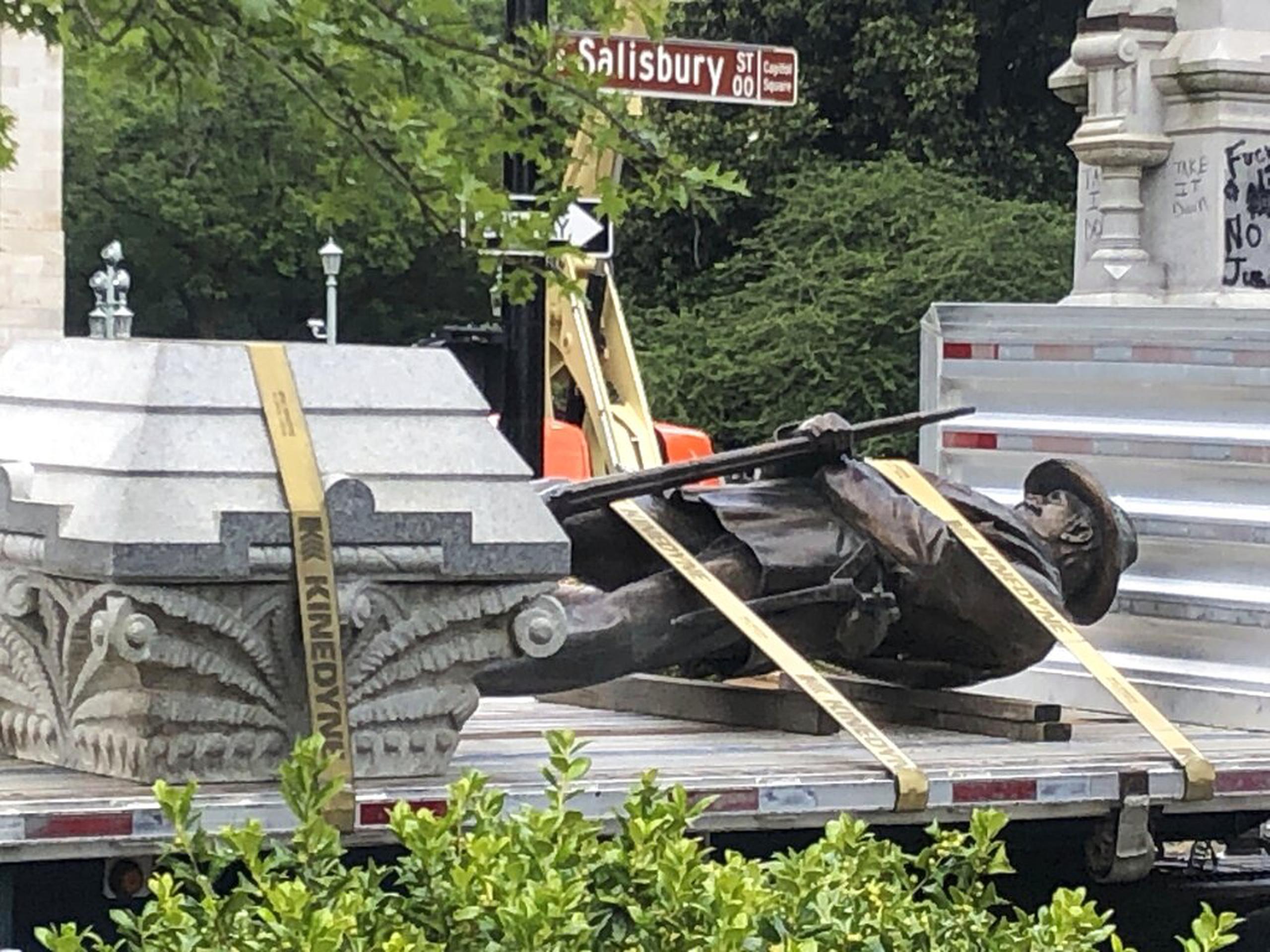 La estatua de un soldado del ejército de la Confederación y su pedestal fueron colocados en un camión de carga el domingo, en el Capitolio de Raleigh.