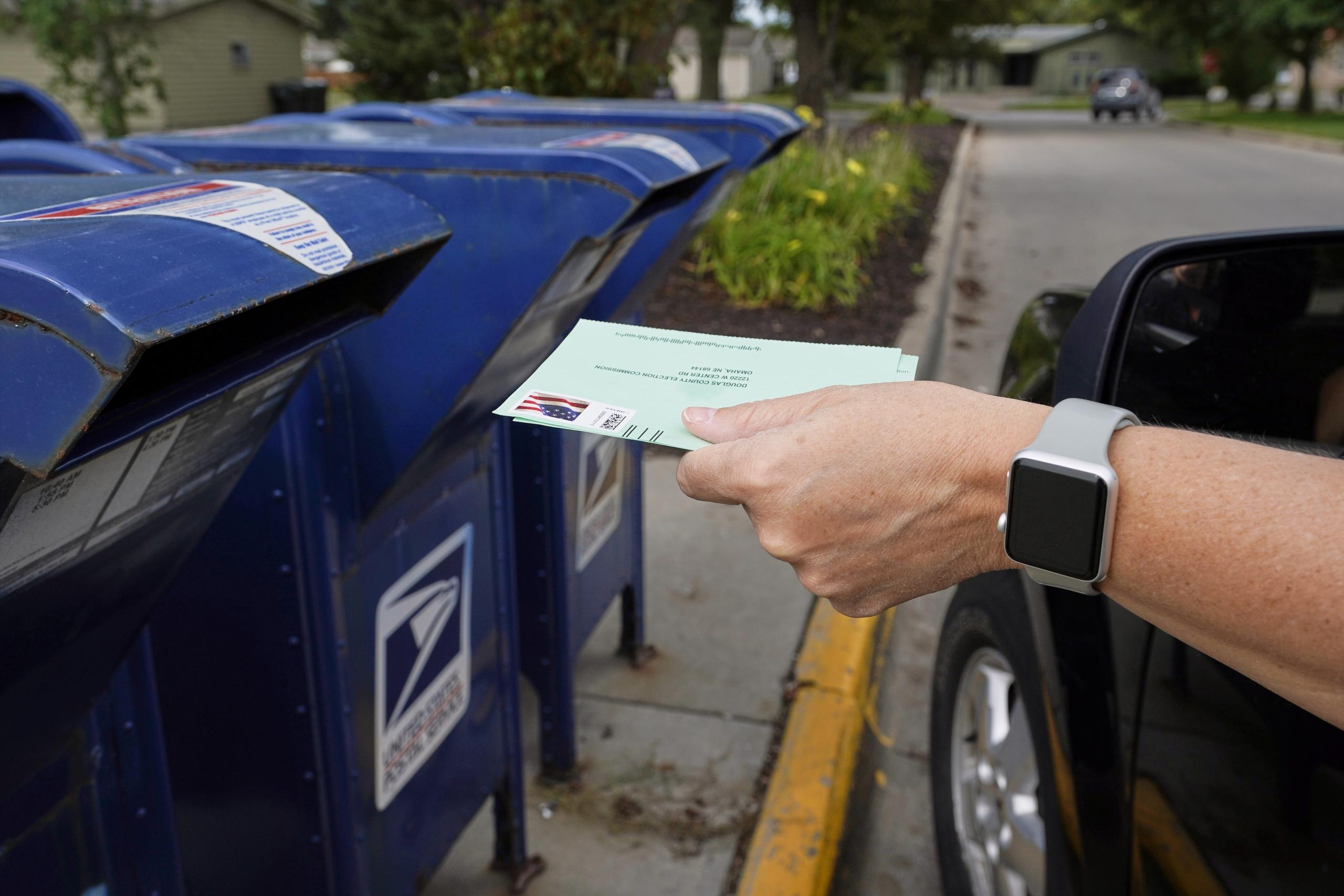 Imagen de archivo de una persona que deposita un voto en una caja de correo postal en in Omaha, Nebraska, Estados Unidos.