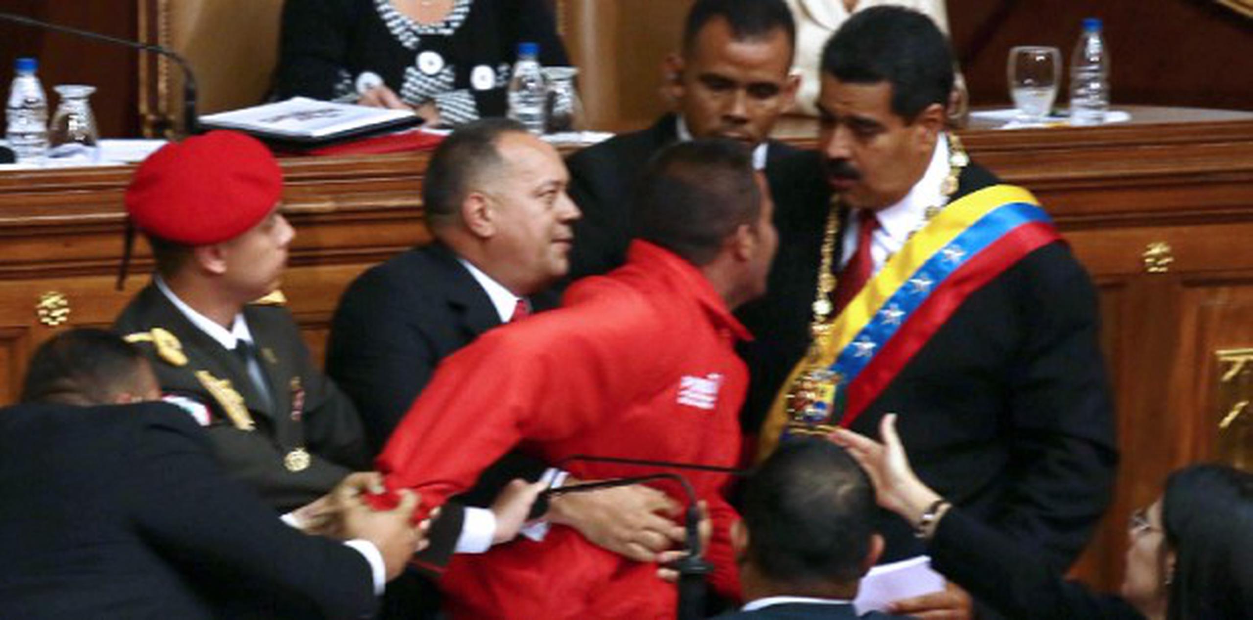 El desconocido tomó el micrófono desde el que hablaba Maduro y gritó "¡Nicolás!, ¡Nicolás!", cuando tres hombres de seguridad se abalanzaron sobre él y lo sacaron del recinto.
 (AFP/Leo Ramirez)