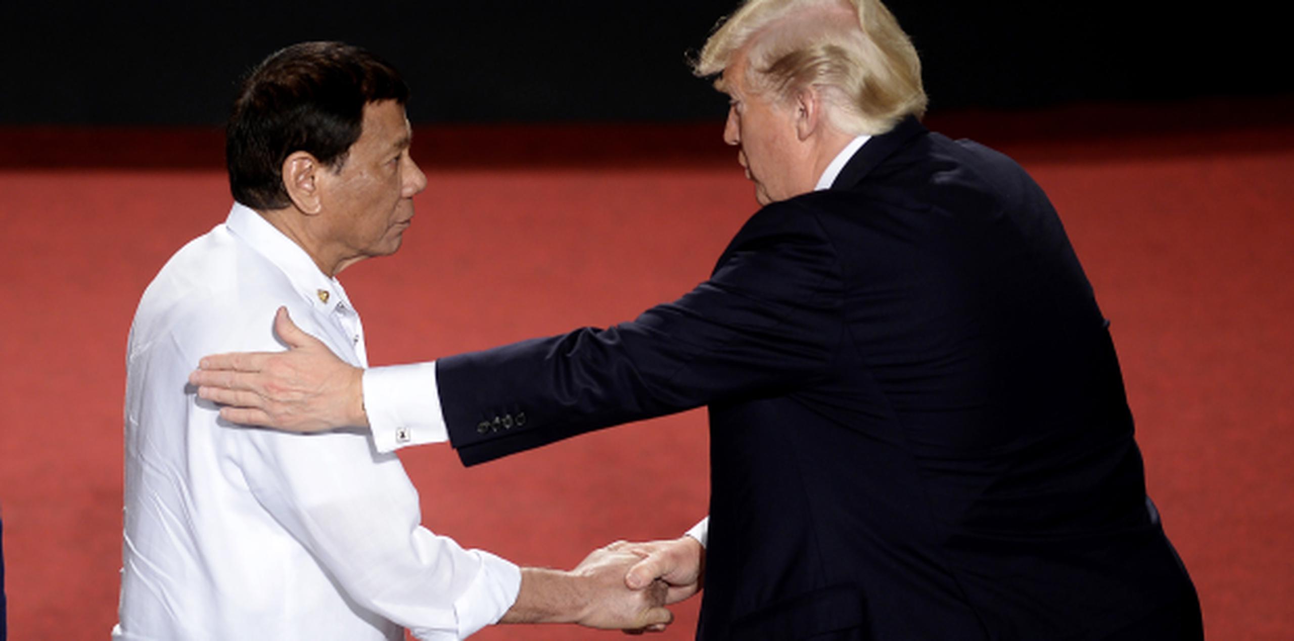 Duterte, aquí con un fuerte apretón de Trump, se ha jactado de haber matado a personas con sus propias manos. (AP)

