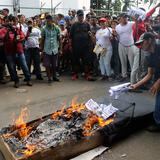 Migrantes protestan con un ataúd y las manos encadenadas en la frontera sur de México