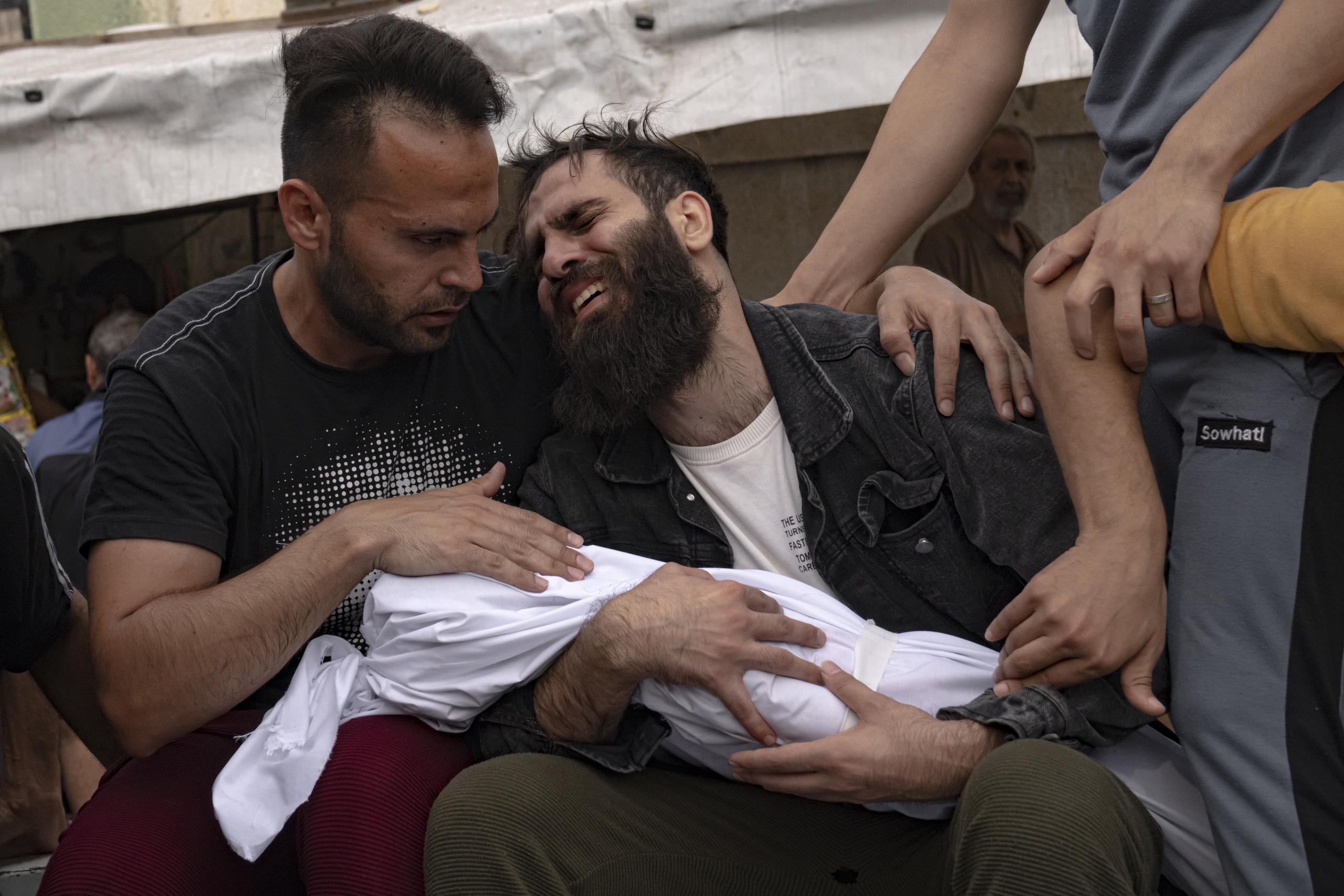 Palestinos lloran a familiares muertos en bombardeos israelíes sobre la Franja de Gaza, en una morgue en Khan Younis, el domigno 29 de octubre de 2023.  (AP Foto/Fatima Shbair)