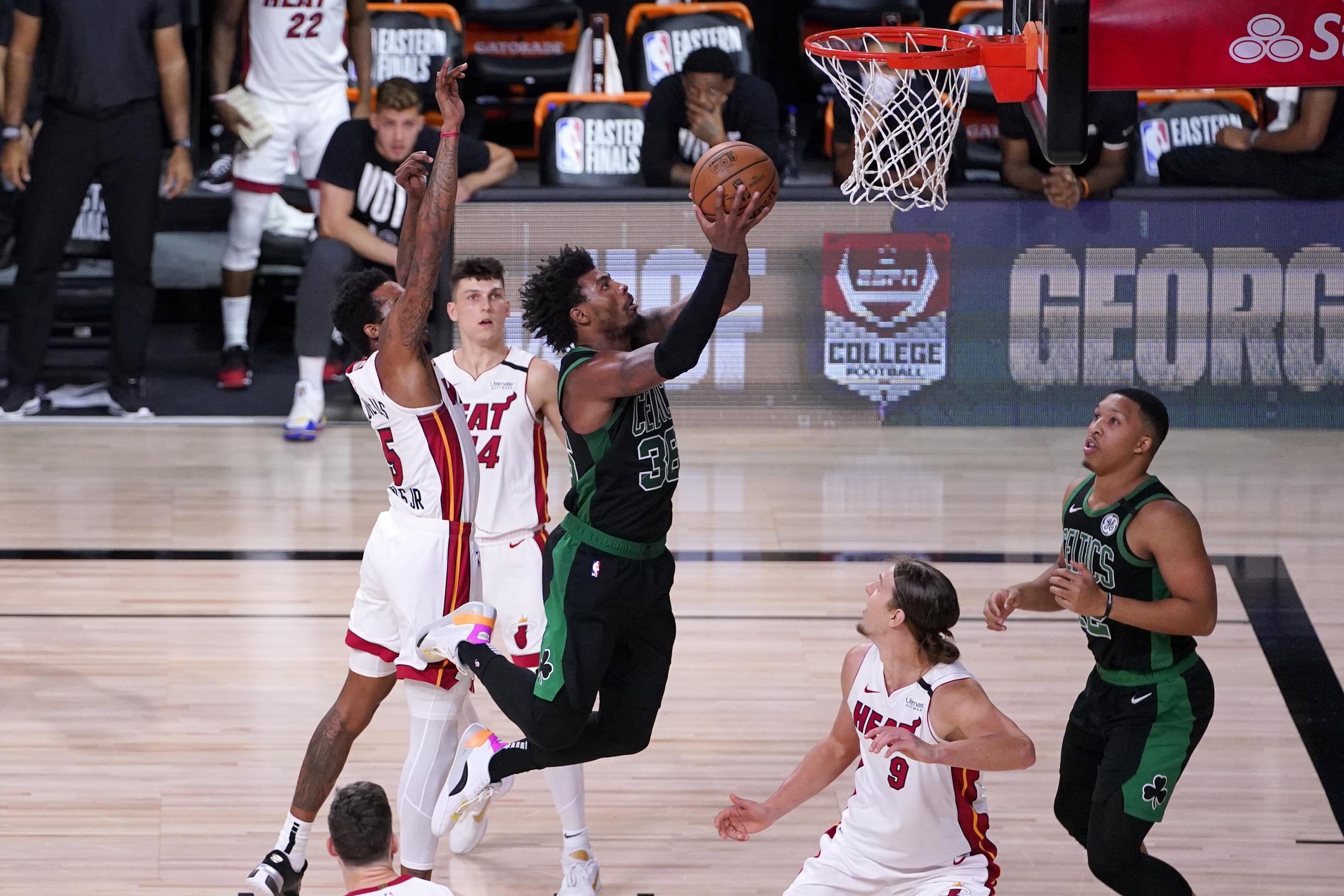 El armador de los Celtics Marcus Smart intenta anotar contra la defensa del Heat.