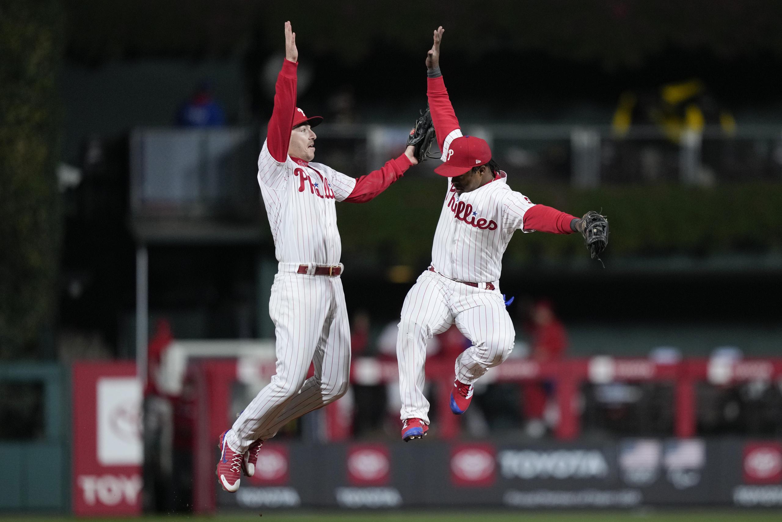 Bryson Stott y el dominicano Jean Segura, izquierda y derecha, respectivamente, saltan para festejar la victoria de los Phillies de Filadelfia el sábado sobre los Padres de San Diego en el cuarto juego de la Serie de Campeonato de la Liga Nacional.