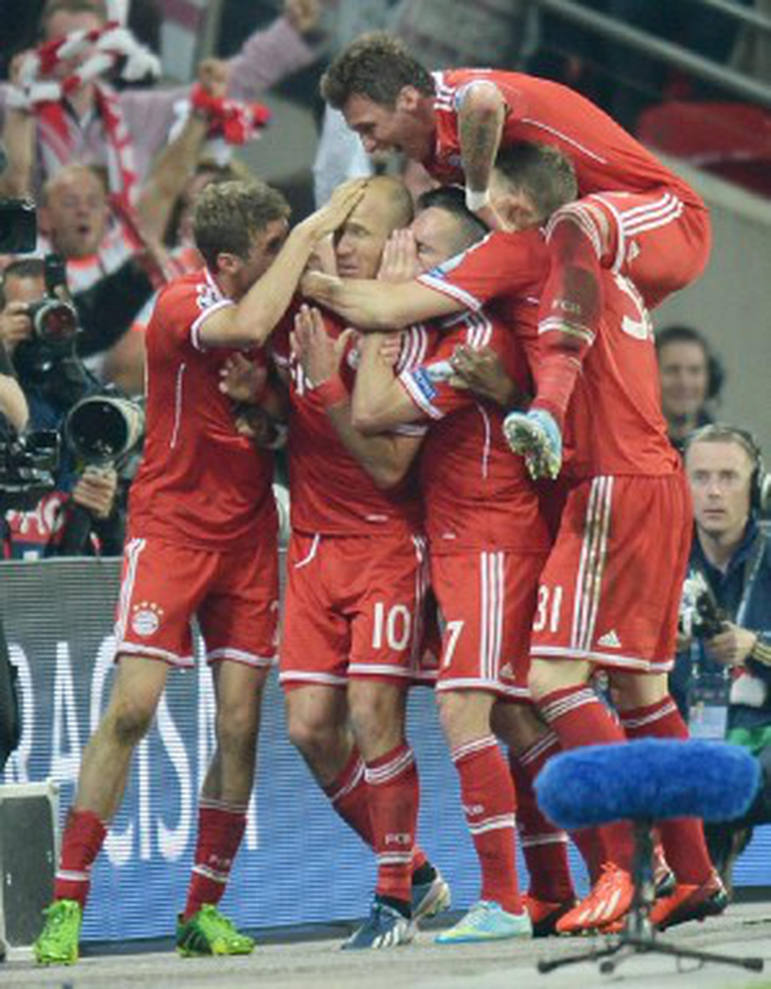 El estelar futbolista del Bayern Munich, Arjen Robben, es celebrado por sus compañeros luego de anotar el gol de la victoria a los 89  minutos del desafío. (Andy Rain / EFE).