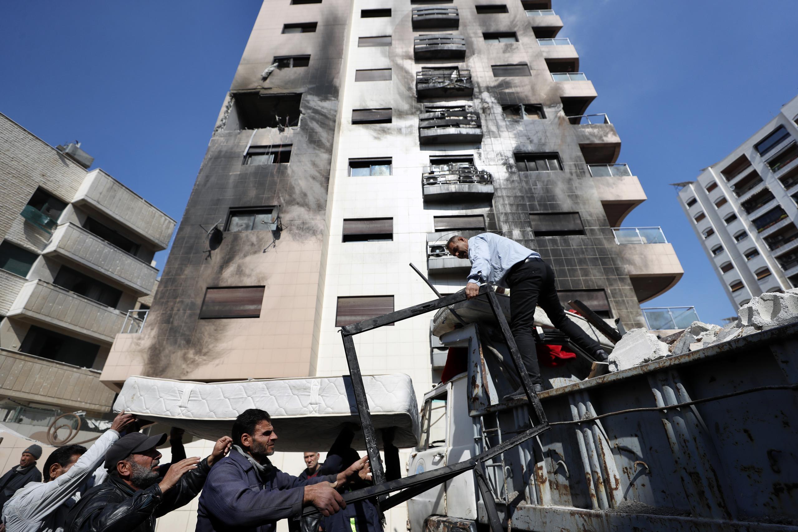 Varias personas retiran los escombros tras un ataque atribuido a Israel en Siria, según la televisora estatal siria, en el distrito de Kfar Sousseh, en Damasco, Siria, el 21 de febrero de 2024. (AP Foto/Omar Sanadiki)