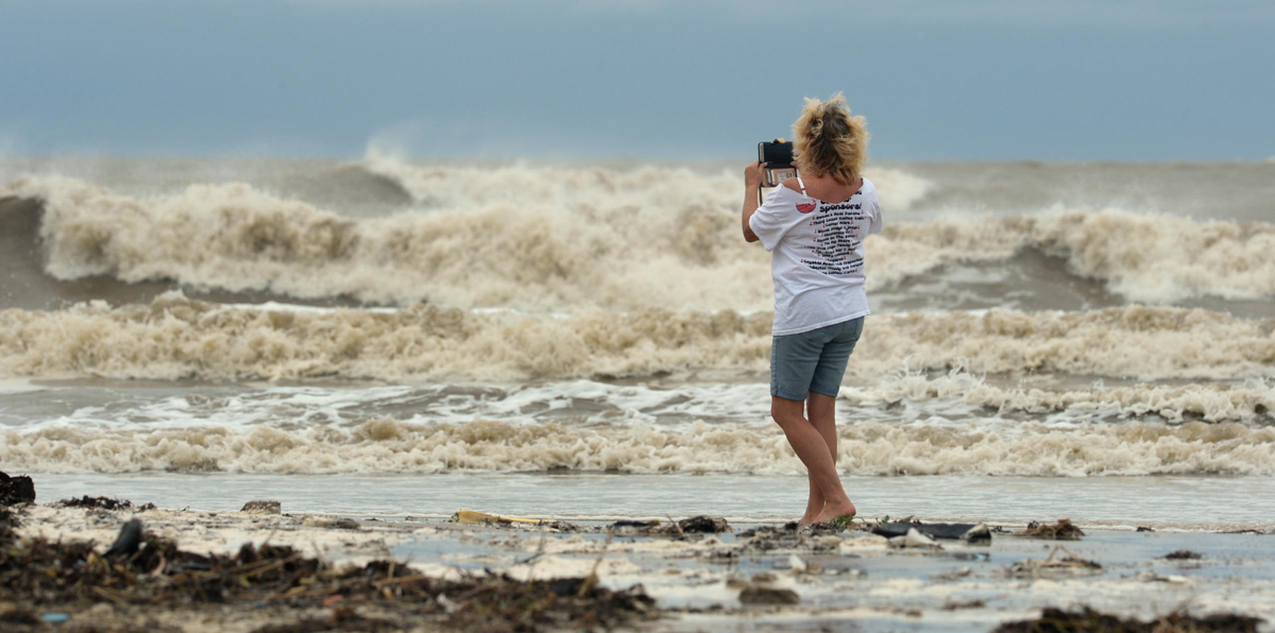 Tricia Hayes graba imágenes en la orilla antes de la llegada del tormenta tropical Cindy, en la península Bolivar, Texas. (AP)