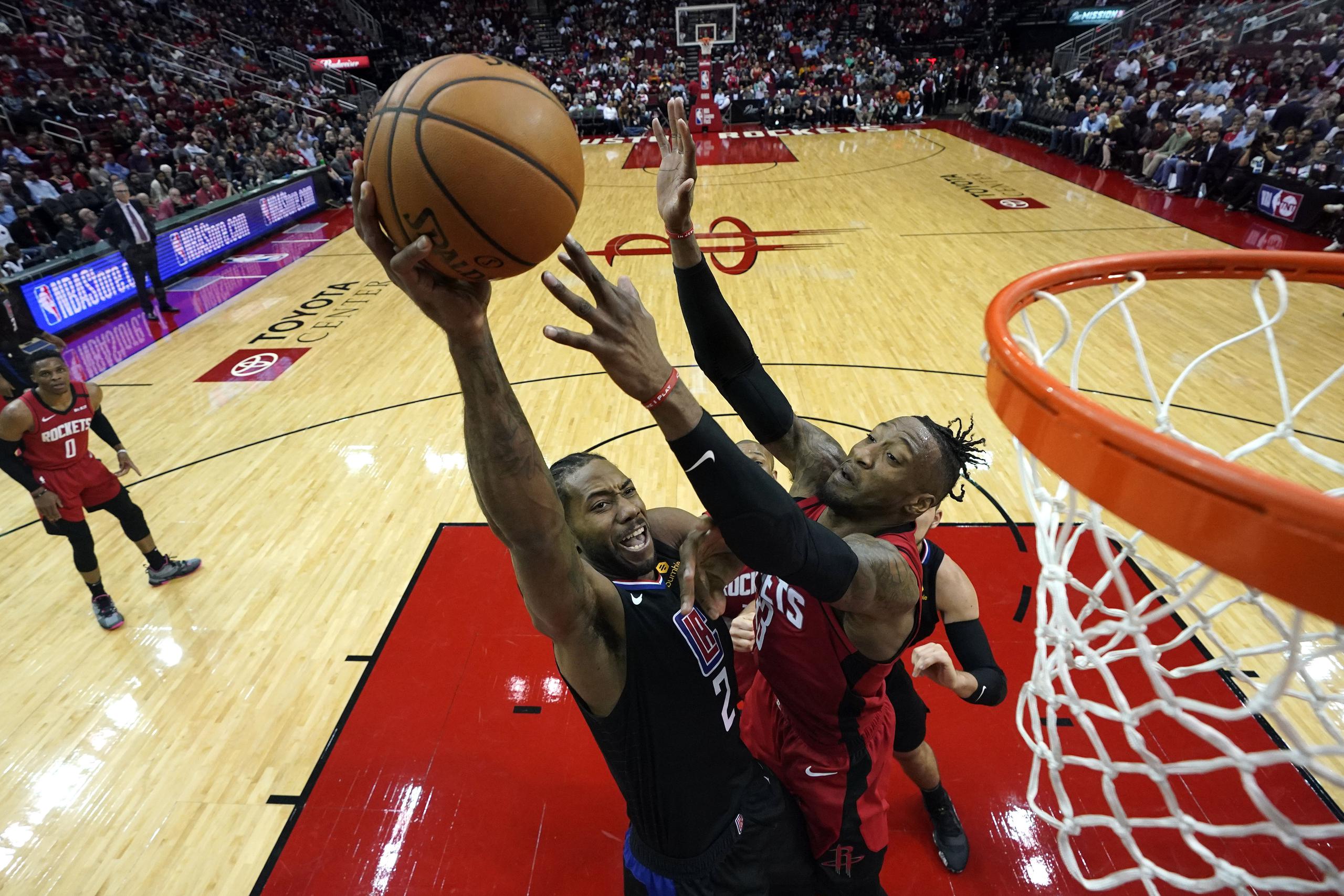 Kawhi Leonard salta para encestar por los Clippers de Los Ángeles frente a Robert Covington, de los Rockets de Houston.