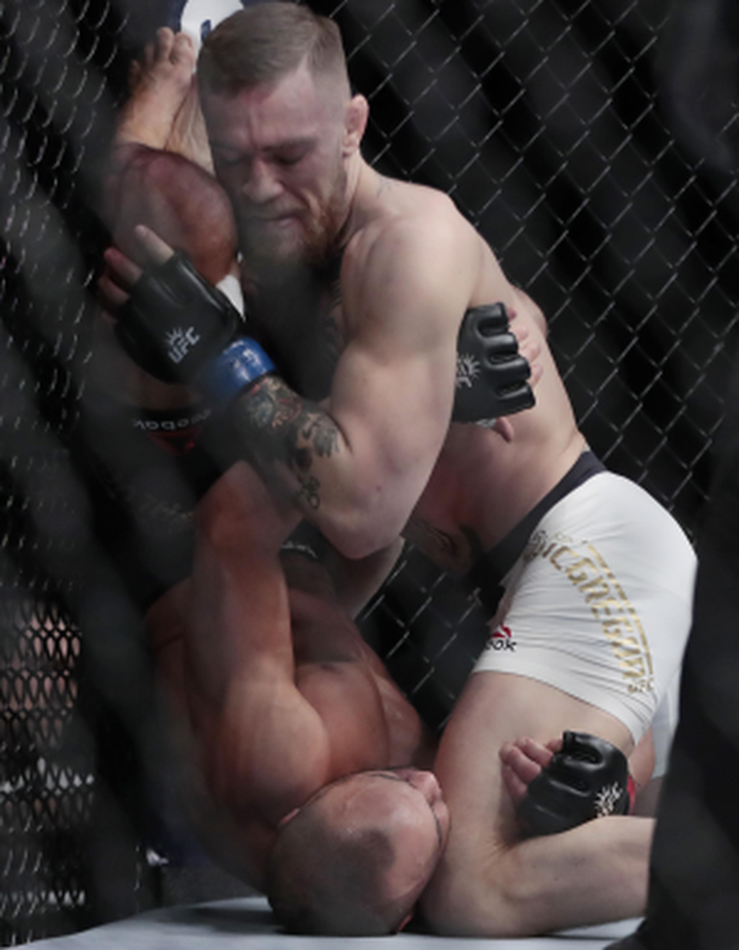 McGregor arrincona a Álvarez durante su combate de anoche. (AP)