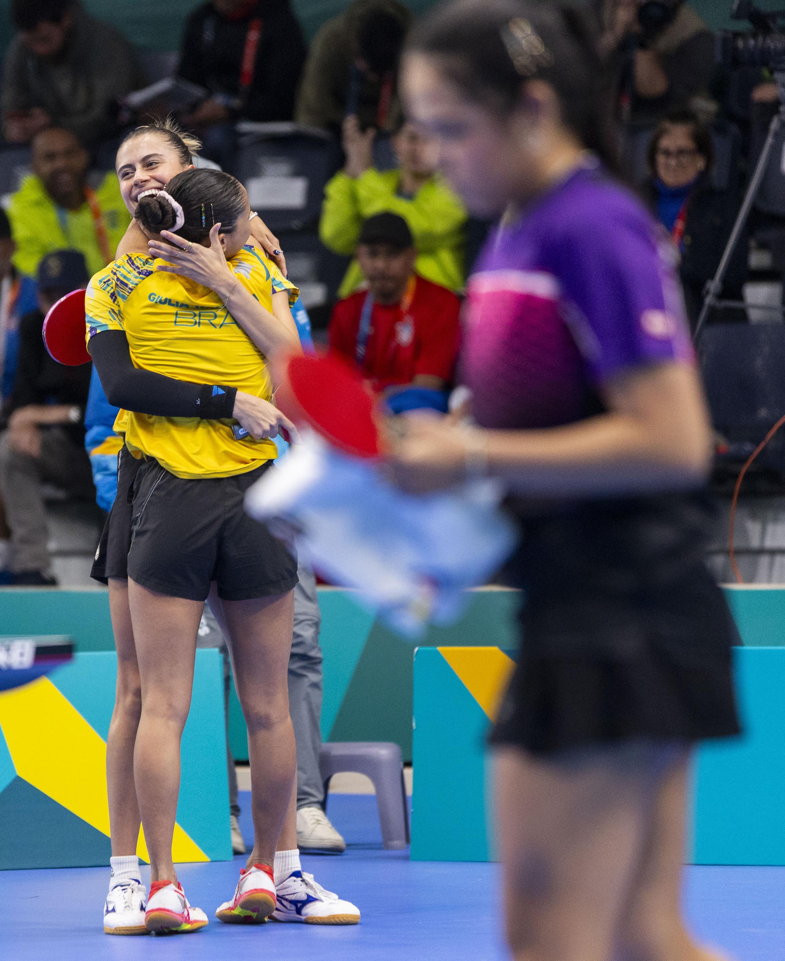 Las hermanas brasileñas Bruna y Giulia Takahashi celebran su victoria mientras al frente, fuera de foco, se puede ver a Adriana Díaz mostrando la tristeza del revés.