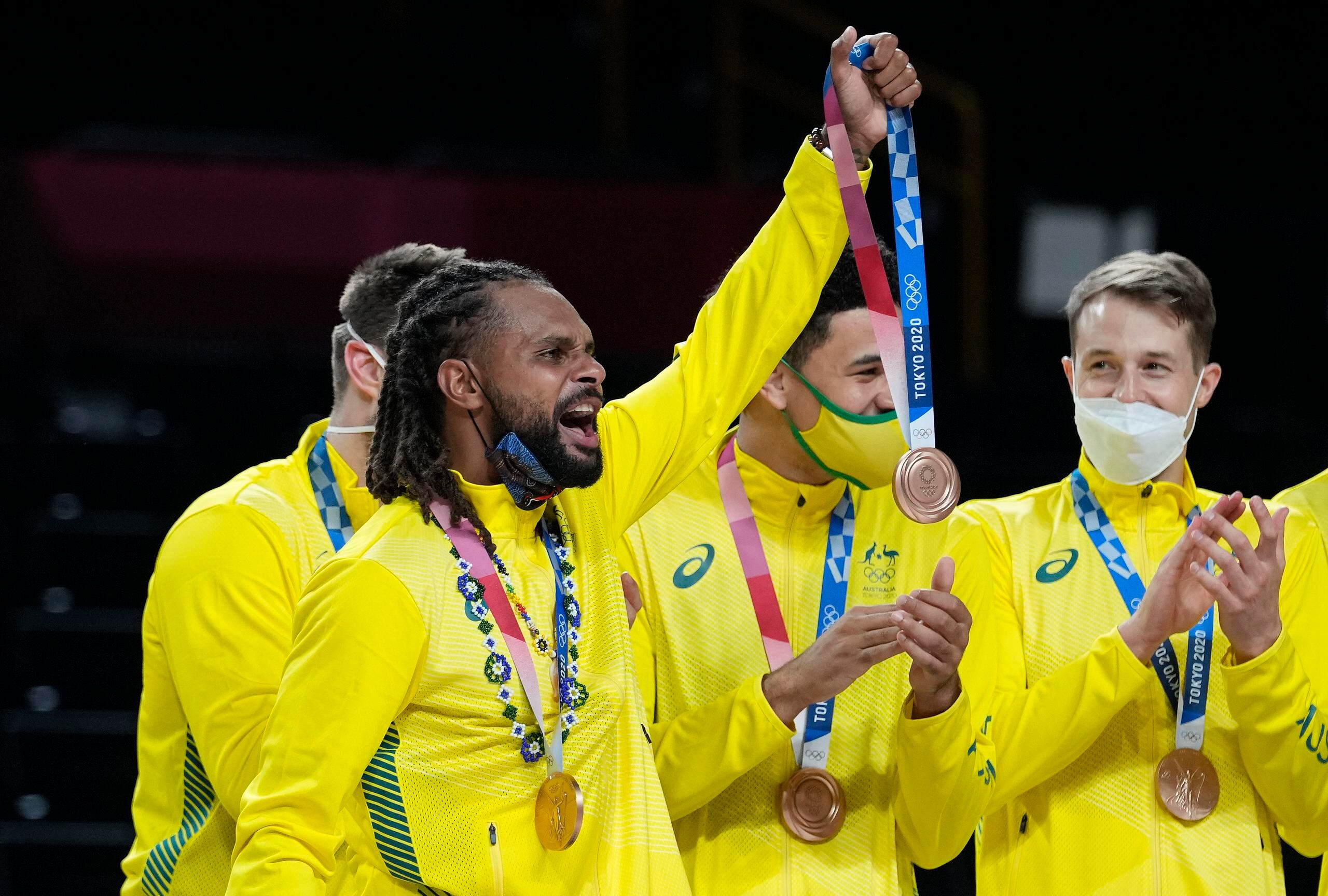 Patty Mills sostiene la medalla de bronce de un compañero lesionado durante la premiación del sábado. Australia derrotó a Eslovenia para quedarse con el tercer lugar.