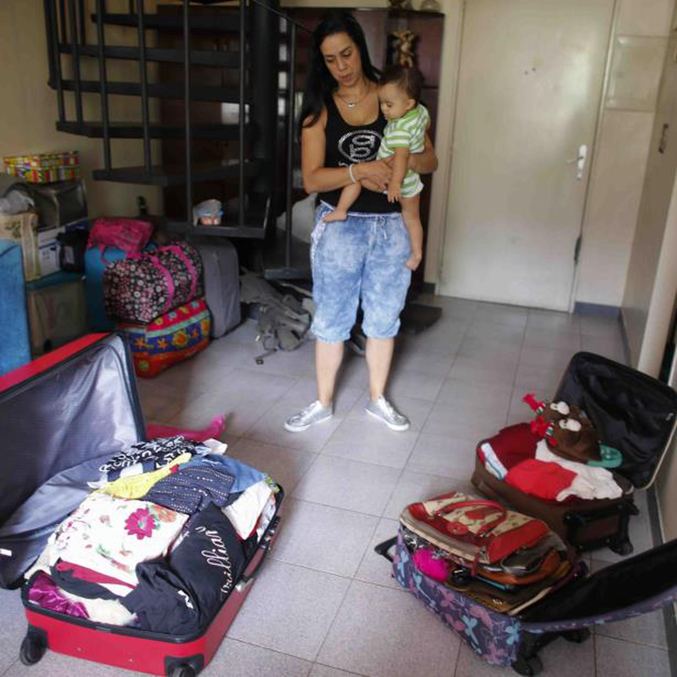 Yenika Calderón, de 41 años, espera vender todas las cosas empacadas en sus maletas para poder irse a España con su hijo Gael, de 10 meses y empezar una nueva vida tras la devastación en el suyo. (AP/Ariana Cubillos)
