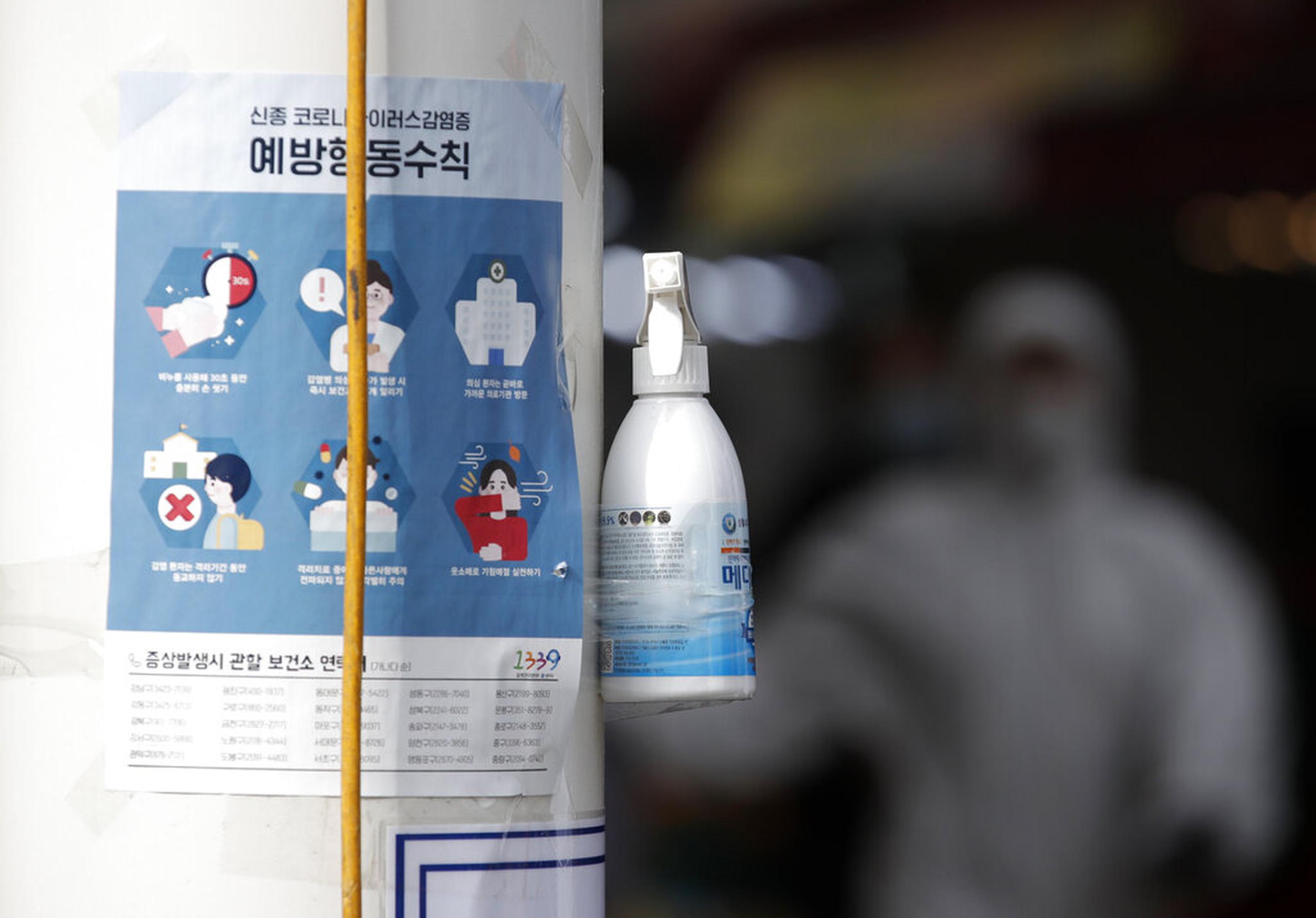Botella de gel sanitario para las manos colgada en un poste en Corea del Sur.