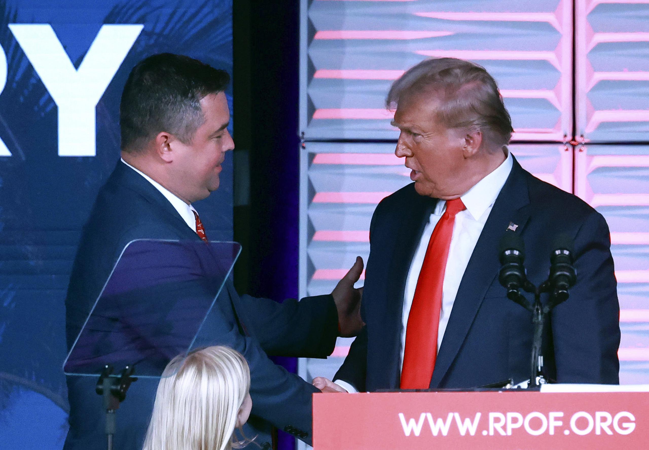 El presidente del Partido Republicano de Florida Christian Ziegler, izquierda, saluda al expresidente Donald Trump en la Cumbre RPOF Freedom, el 4 de noviembre de 2023 en Kissimmee, Florida. (Joe Burbank/Orlando Sentinel vía AP)