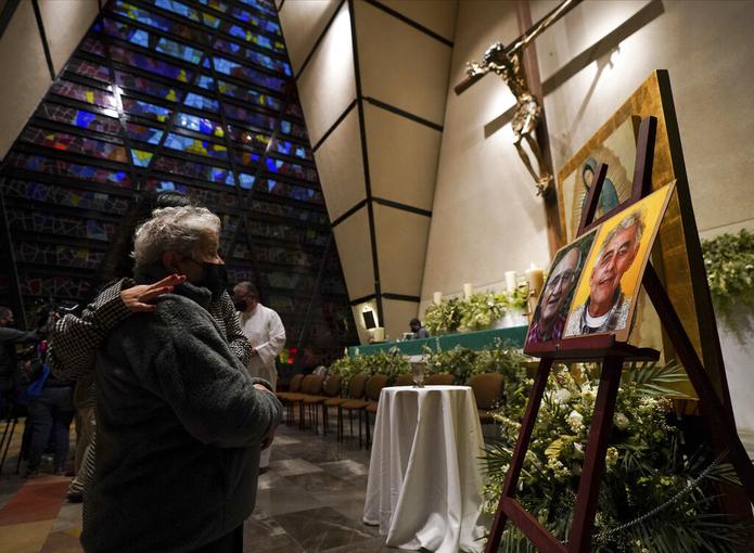 Una feligrés se lamenta frente a las imágenes de los sacerdotes jesuitas Javier Campos Morales y Joaquín César Mora Salazar durante una misa el 21 de junio de 2022, en la Ciudad de México.