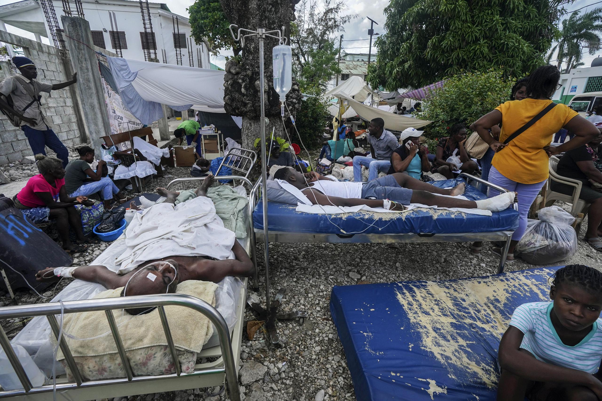 Heridos esperan por atención médica en camas a la intemperie fuera del Hospital de la Inmaculada Concepción en Les Cayes.