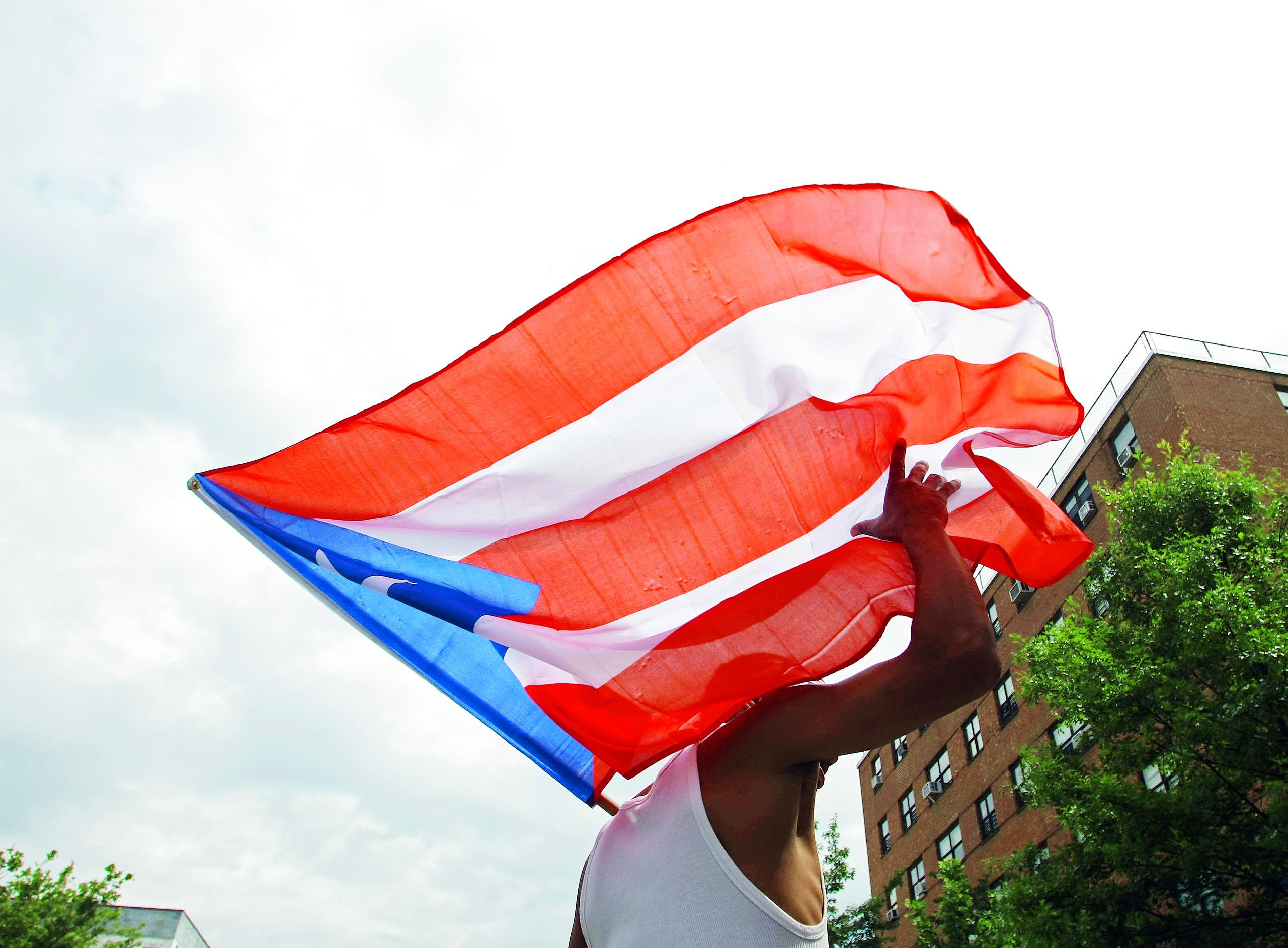 Un hombre ondea una bandera de Puerto Rico.