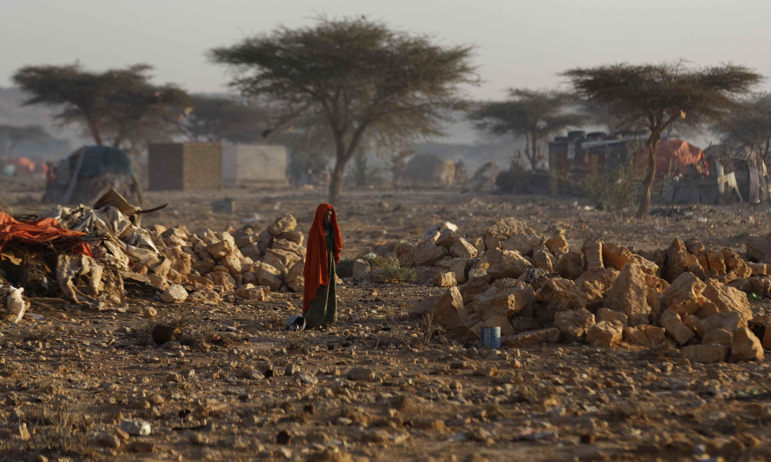 Una mujer somalí camina a través de un campamento de personas desplazadas de sus viviendas en otras partes del país debido a la sequía, poco después del amanecer en Qardho, Somalia, el jueves 9 de marzo de 2017. (AP)