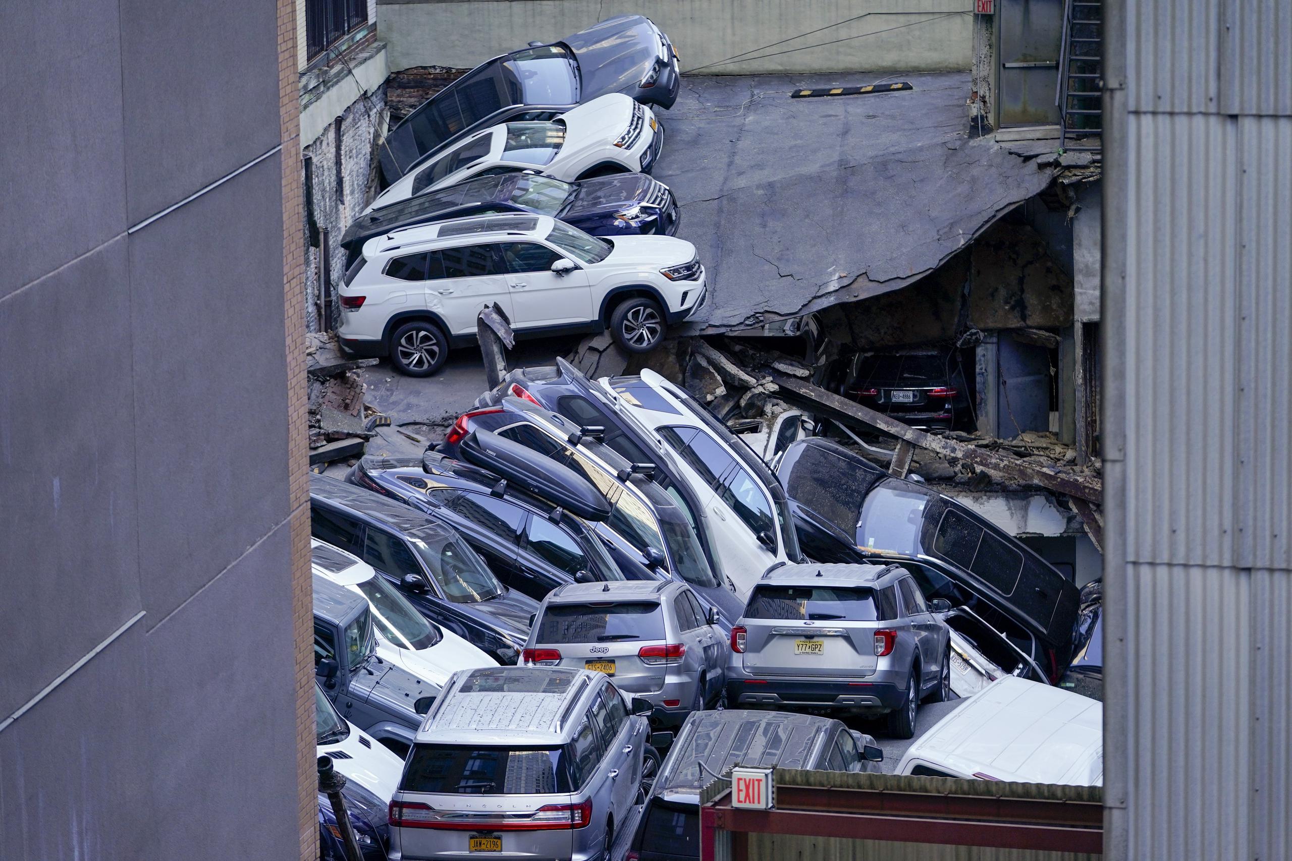 Vehículos apilados unos encima de otros en el lugar en el que un estacionamiento sufrió un derrumbe parcial, el martes 18 de abril de 2023, en el distrito financiero de la ciudad de Nueva York. (AP Foto/Mary Altaffer)
