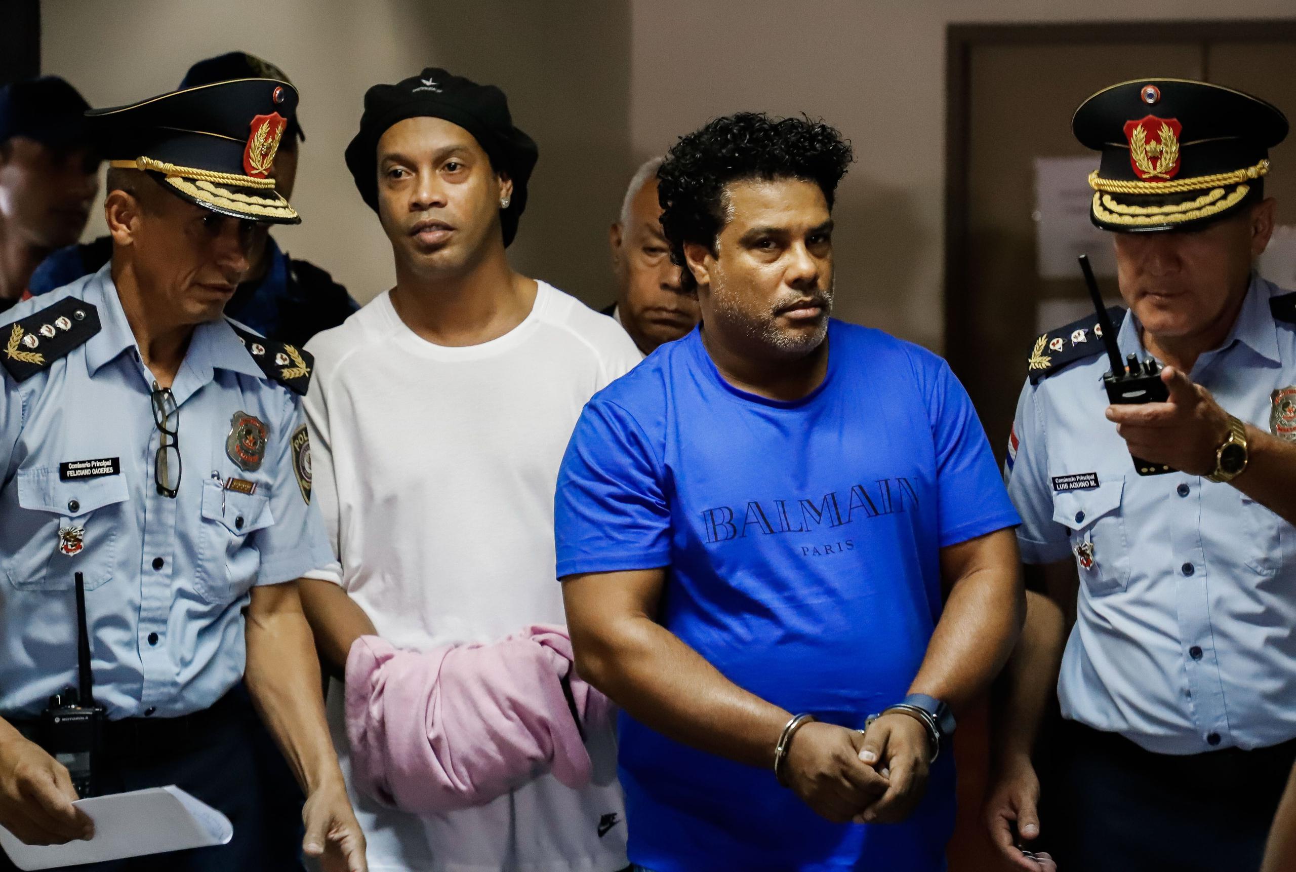 El exinternacional brasileño Ronaldinho Gáucho (2d) y su hermano Roberto (2i), a su llegada este sábado al Palacio de Justicia, para una nueva audiencia de imposición de medidas, tras ser detenidos el viernes e imputados en la causa de los pasaportes falsificados con los que ingresaron en Paraguay.