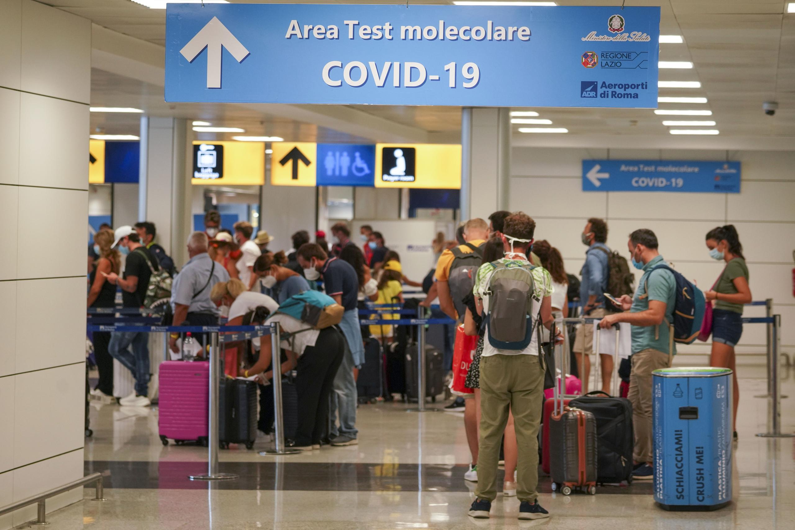Vacacionistas llegan al Aeropuerto Leonardo da Vinci en Roma, Italia, donde son examinados de inmediato por coronavirus, el domingo 16 de agosto de 2020.
