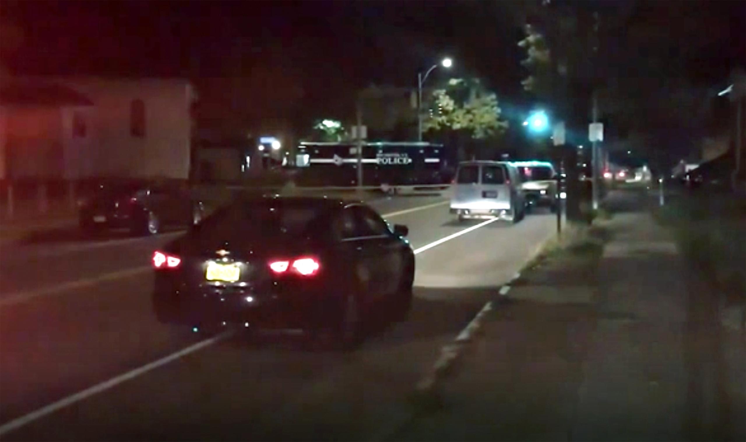 Vehículos de la policía, al fondo, en el sitio de un tiroteo ocurrido esta madrugada en Rochester, Nueva York.
