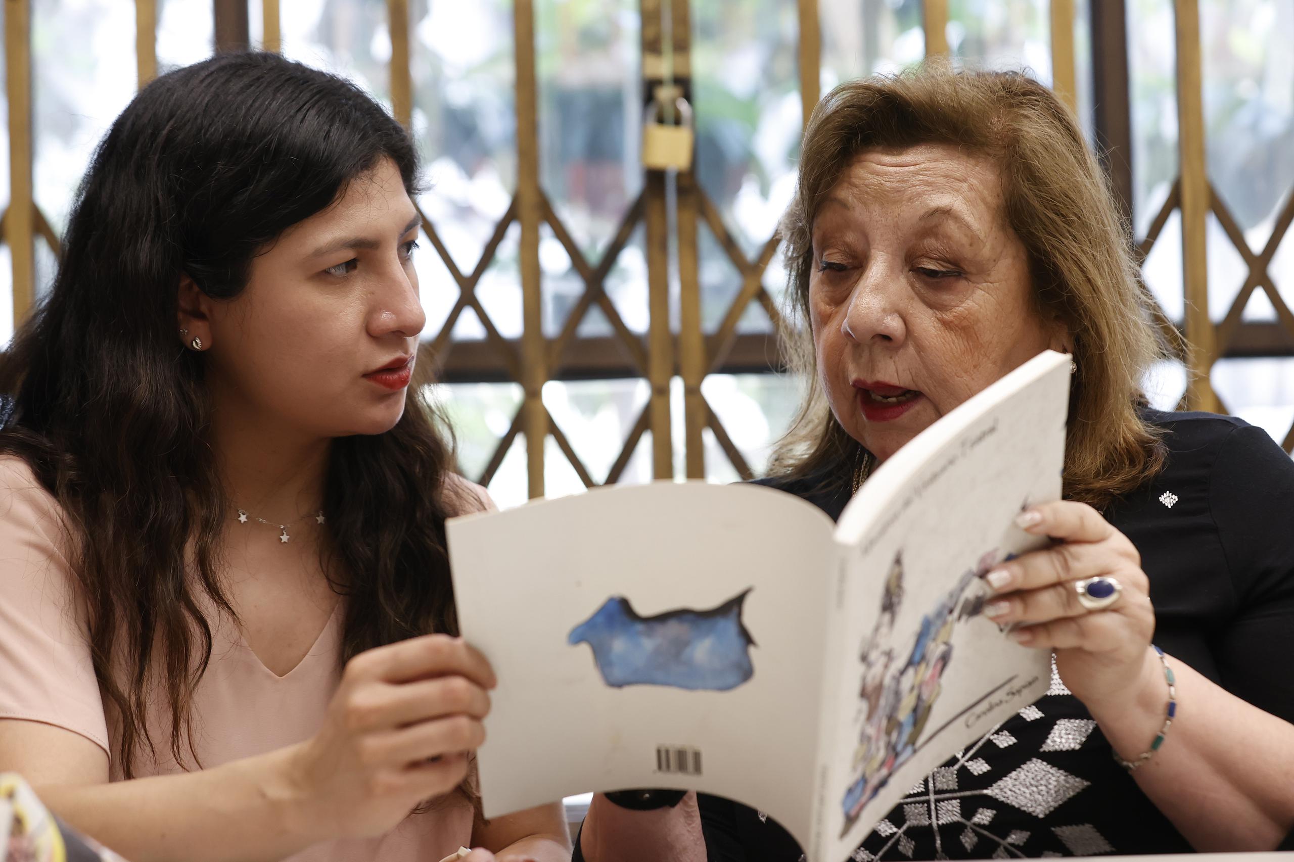 Vitoria Quiroz (d) y María José Zapata (i) participan en un club de lectura en la llamada Biblioteca de las Mujeres, en Santiago, en Chile. (EFE/ Elvis González)