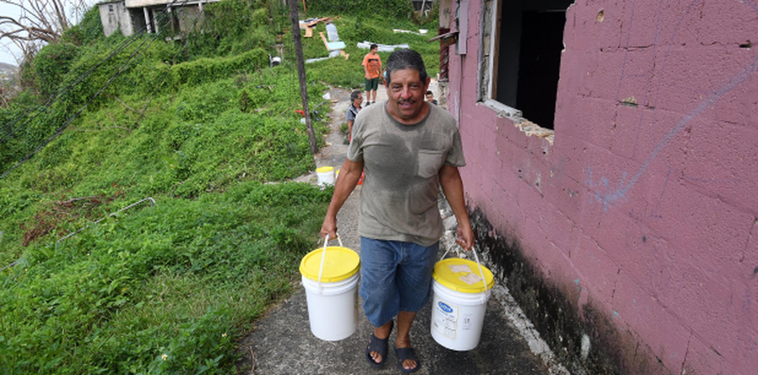 El pastor William Vázquez, de Barrio Pueblo sector Cerro Gandía en Manatí, sube con cubos de agua un promedio de 7 veces al día.(andre.kang@gfrmedia.com)