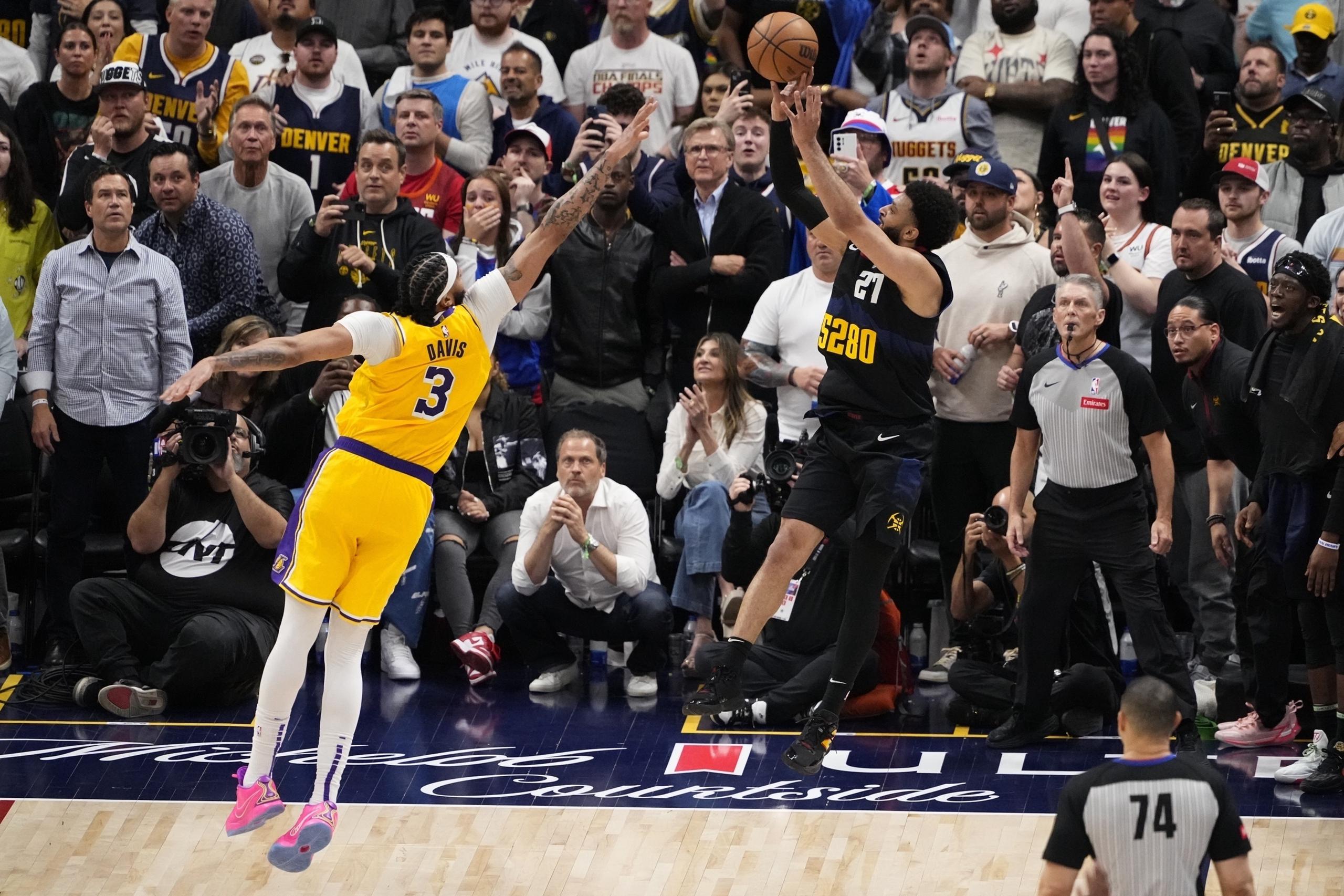 Jamal Murray (27), de los Nuggets de Denver, lanza el tiro ganador con la marca defensiva de Anthony Davis (3), de los Lakers de Los Ángeles, durante la segunda mitad del Juego 2 de la serie de primera ronda de playoffs de baloncesto de la NBA, el lunes 22 de abril de 2024, en Denver. (AP Foto/Jack Dempsey)