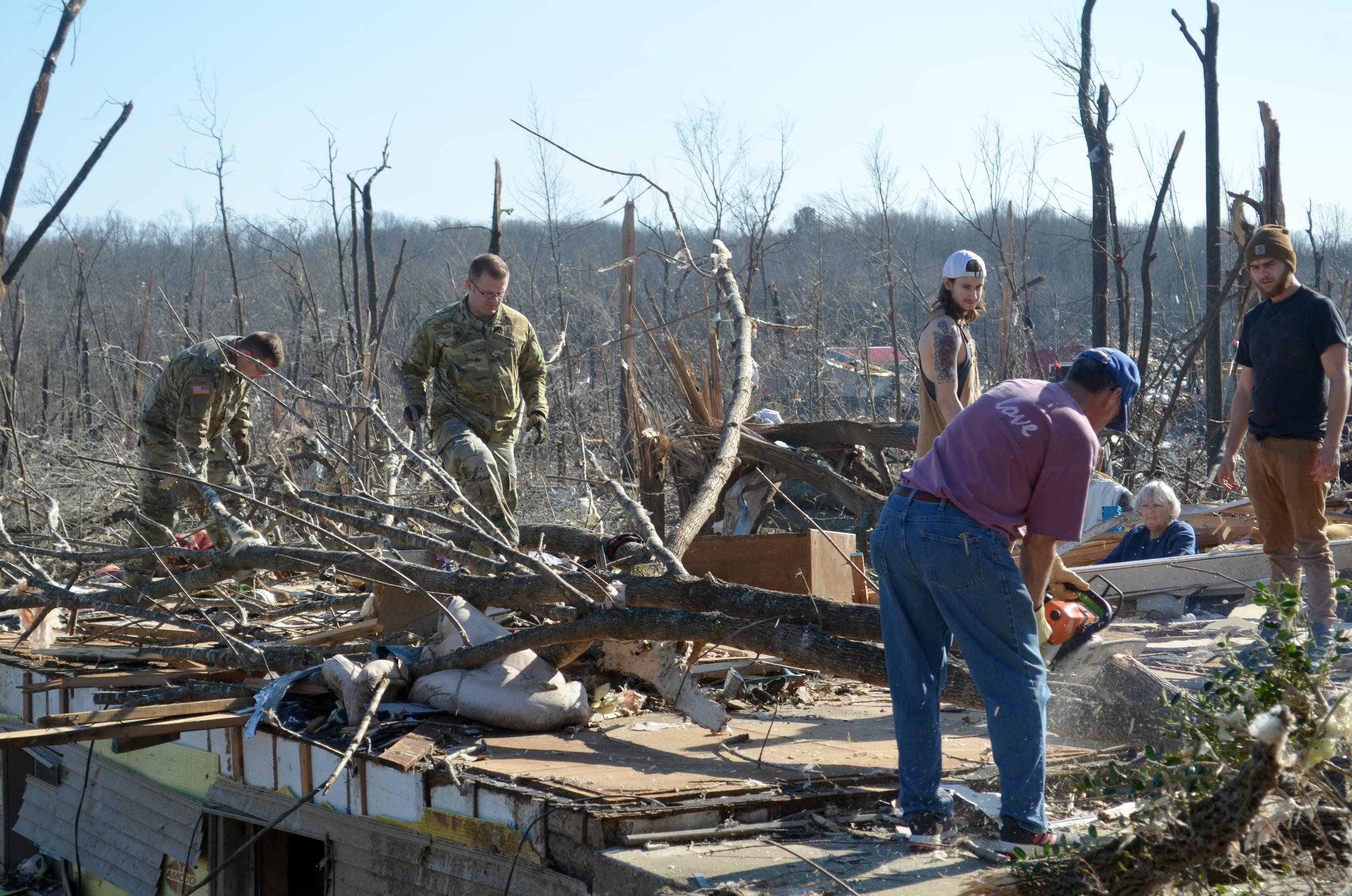 Un grupo de personas fue registrado este martes al levantar escombros, en medio de los destrozos causados por el paso de un tornado, en Cambridge Shores (Kentucky, EE.UU). EFE/Álvaro Blanco
