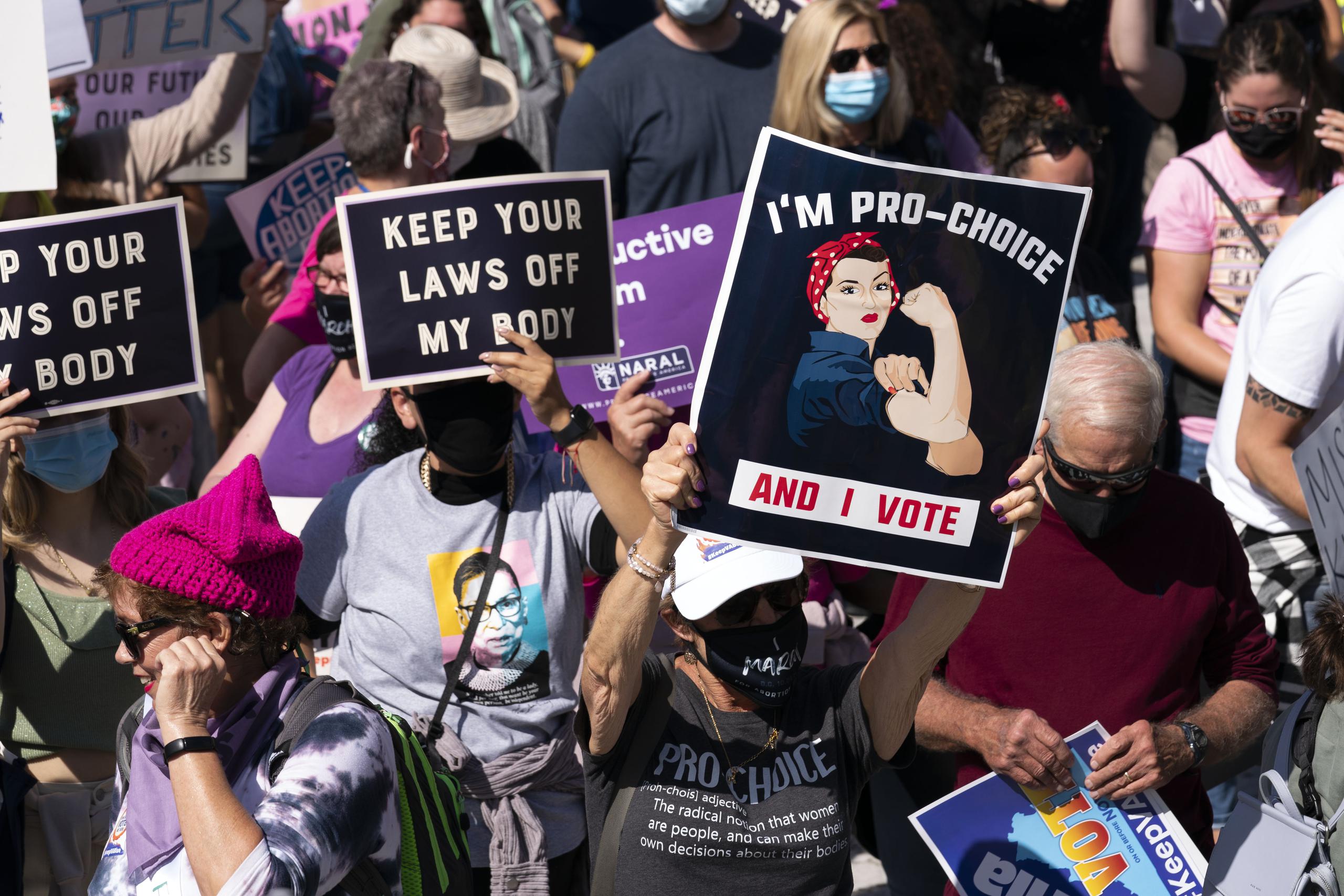Manifestantes llevan carteles en la  Marcha de Mujeres en Washington.