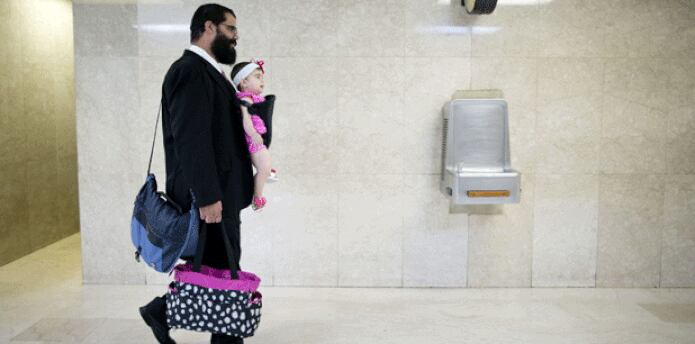 Con su gabán de trabajo, el hombre carga a la nena (que pesa unas 24 libras), su maletín y el colorido bulto de ella. (tonito.zayas@gfrmedia.com)