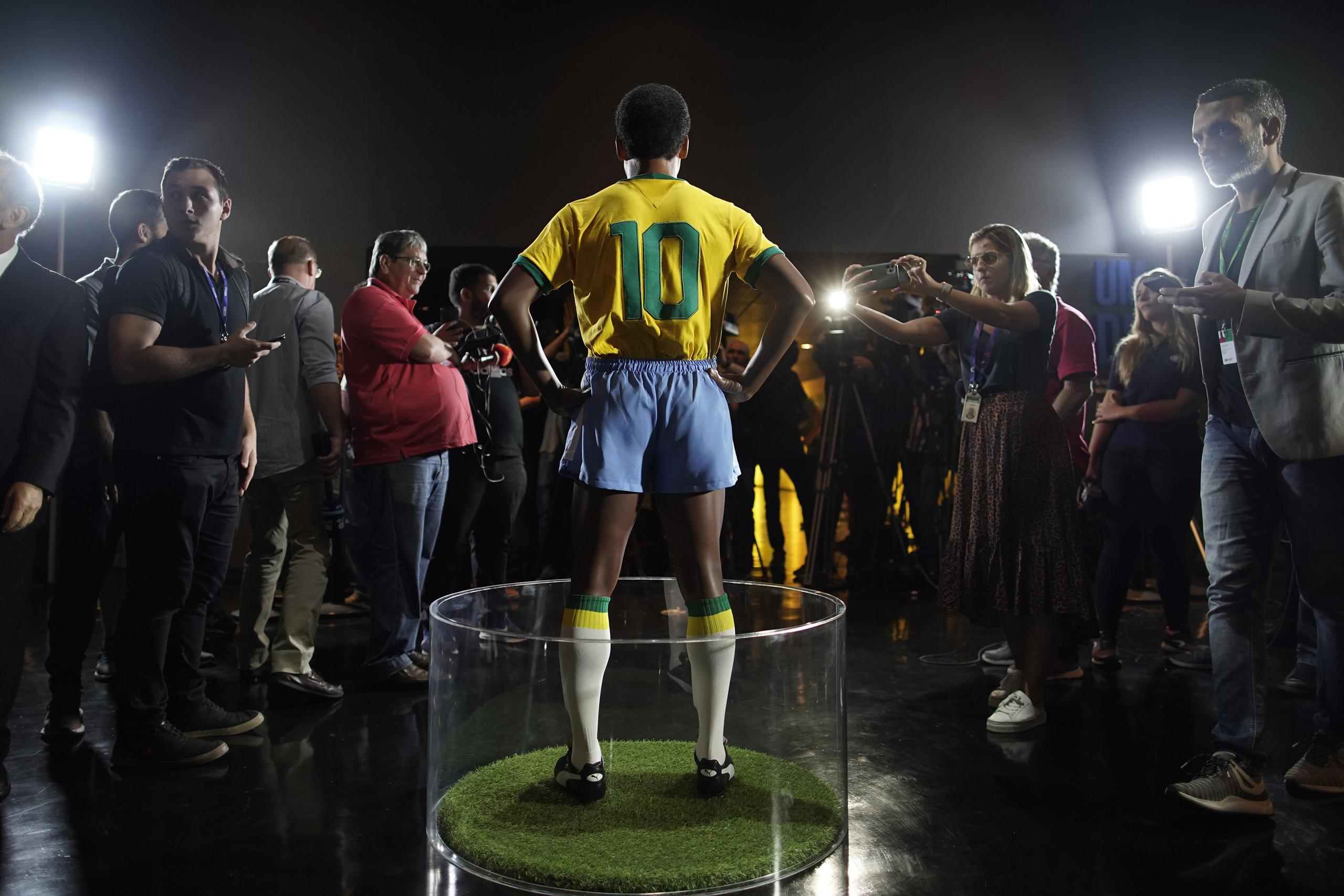 Un grupo de periodistas rodea la estatua de Pelé en el Museo de la Selección Brasileña de Fútbol en Río de Janeiro, el jueves 20 de febrero de 2020. Pelé está hospitalizado para lo que dice son dos días de exámenes médicos rutinarios.